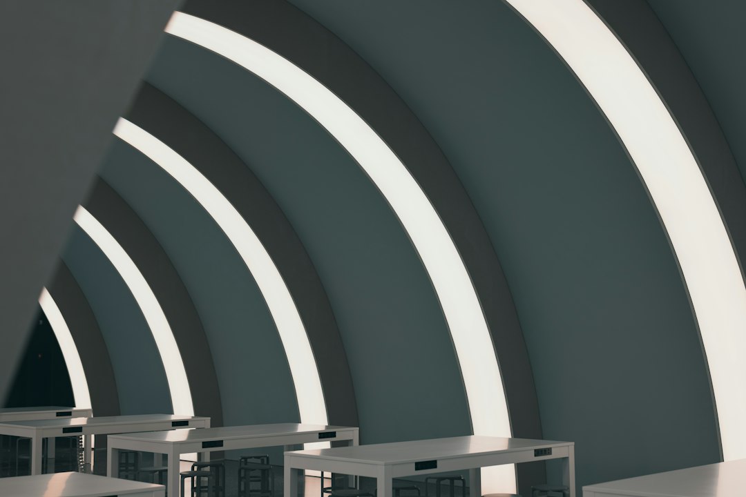 a futuristic office space where two managers are looking at a 3D hologram of a heat map showing incident clusters across various group home locations, high-tech and clinical aesthetics