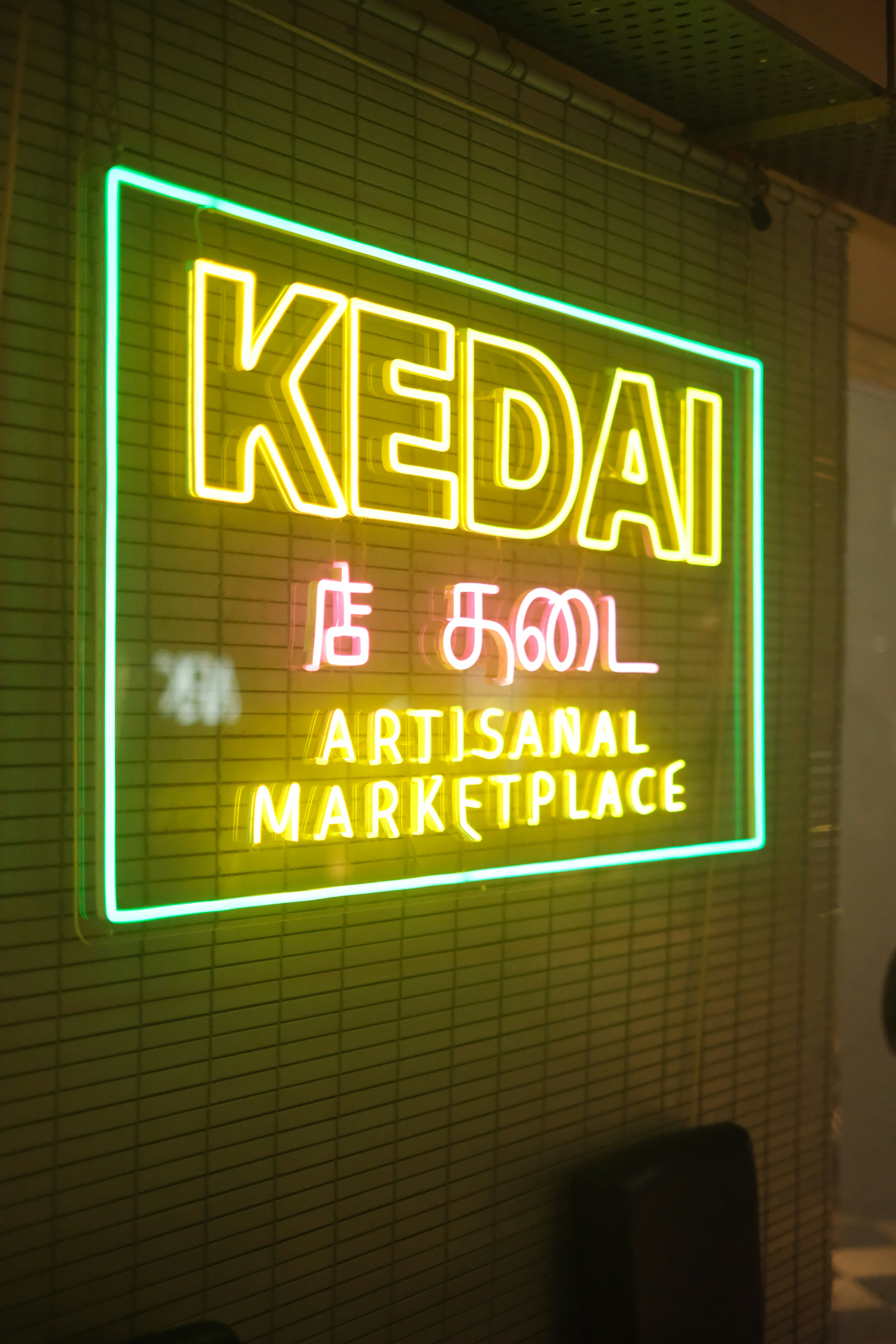 A neon sign that reads keedai is 6001 artisan marketplace