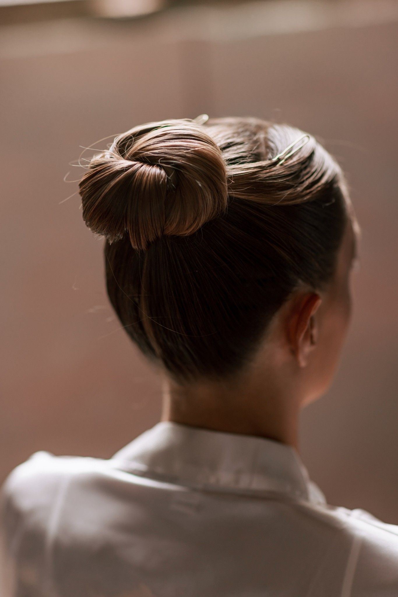Acconciatura della sposa con chignon raccolto, dettaglio dei preparativi matrimoniali a Villa Ferrari