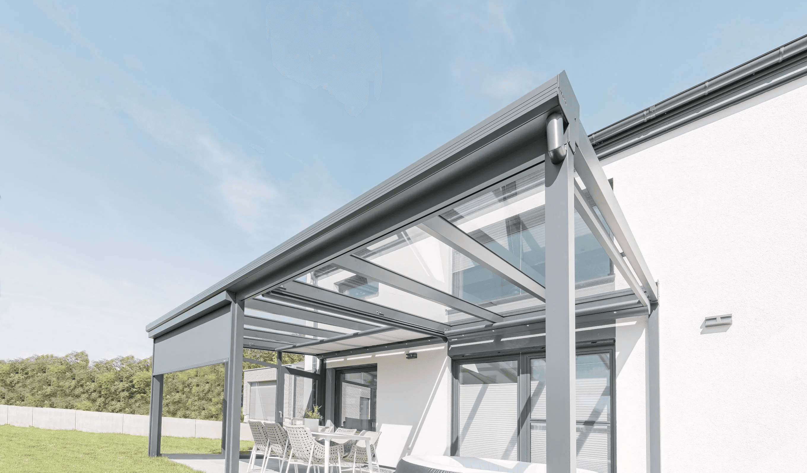 Bild einer Terrassenüberdachung, die bereits teilweise mit Senkrechtmarkise und Seitenwand erweitert wurde