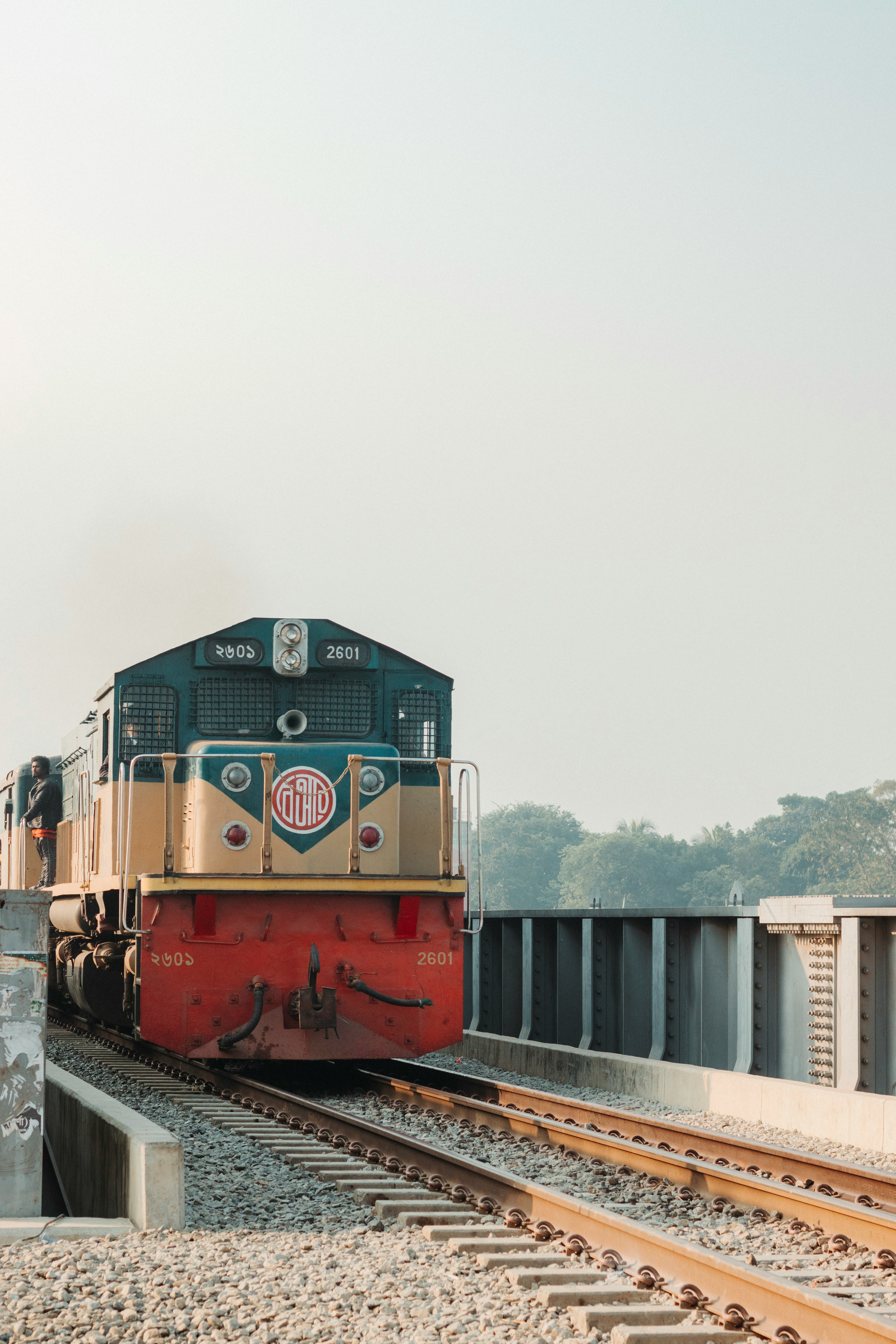 a train traveling down train tracks next to a forest