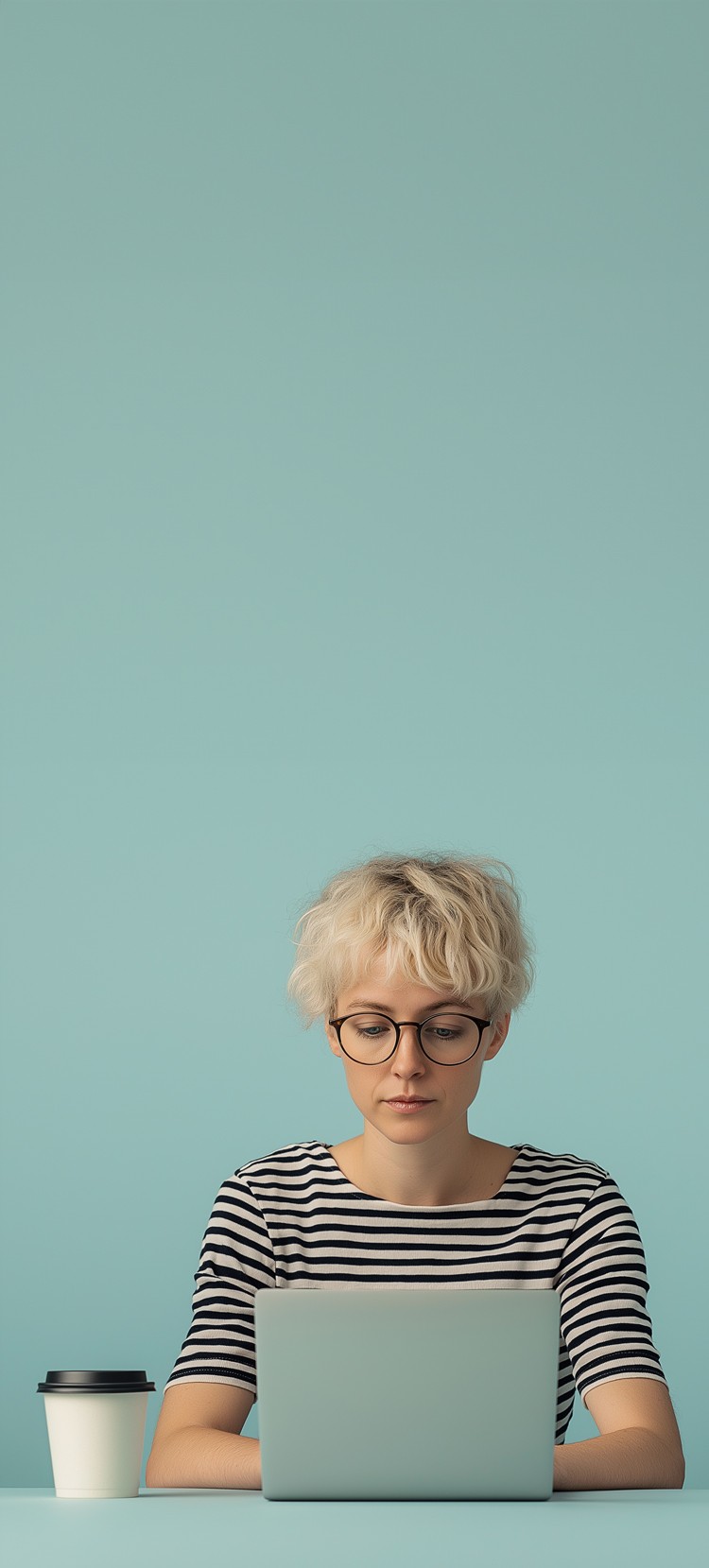 Woman freelancer sitting in front of her laptop in a striped shirt