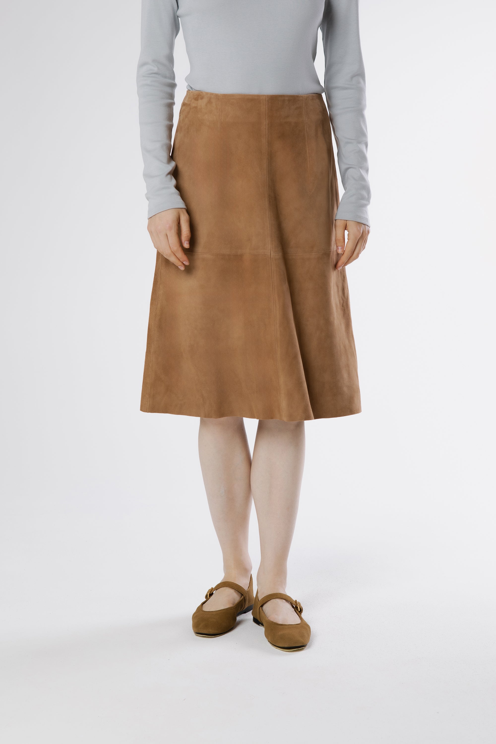 Front view of Otella suede midi skirt in warm oak tone with A-line shape and panel detailing