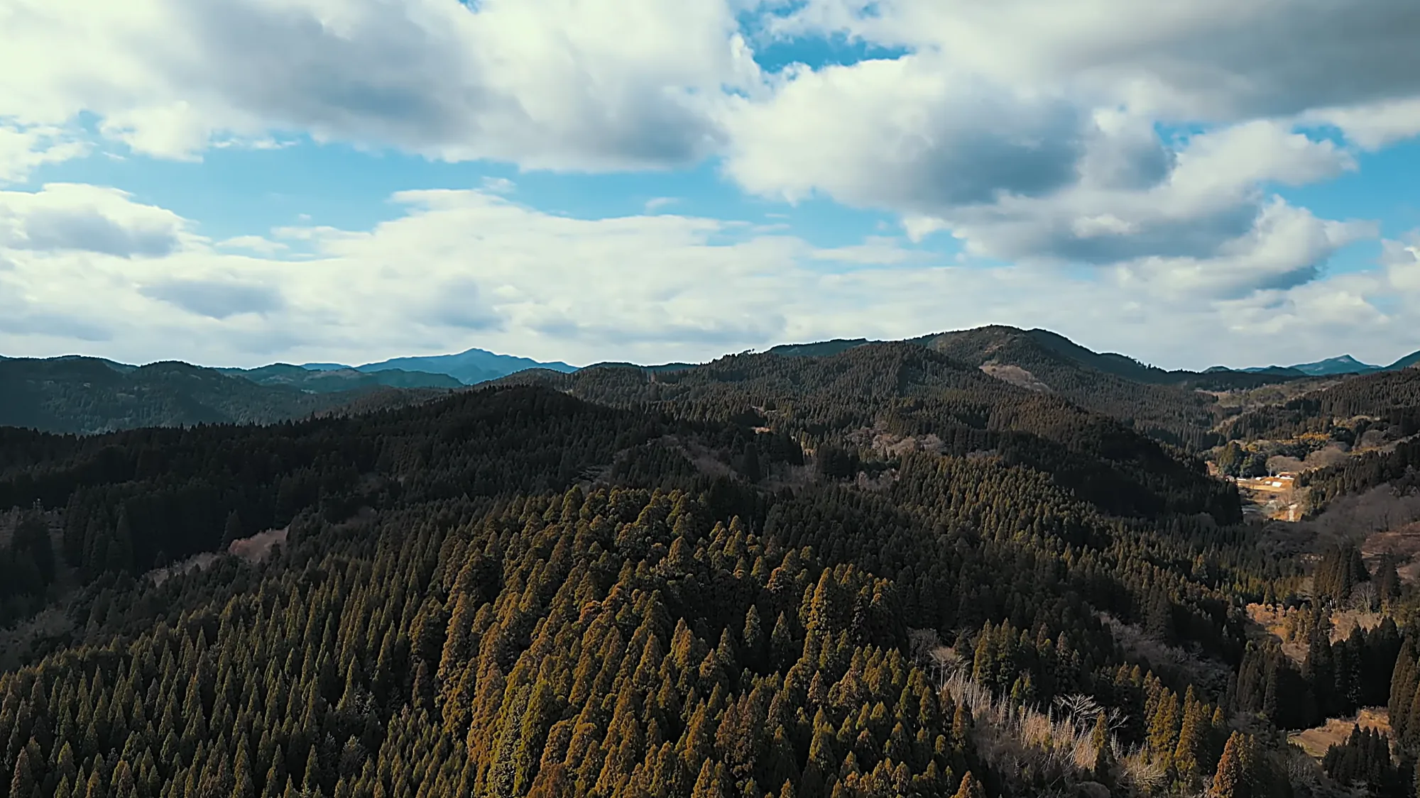 Rolling forested hills under a wide sky around Kurokawa Onsen