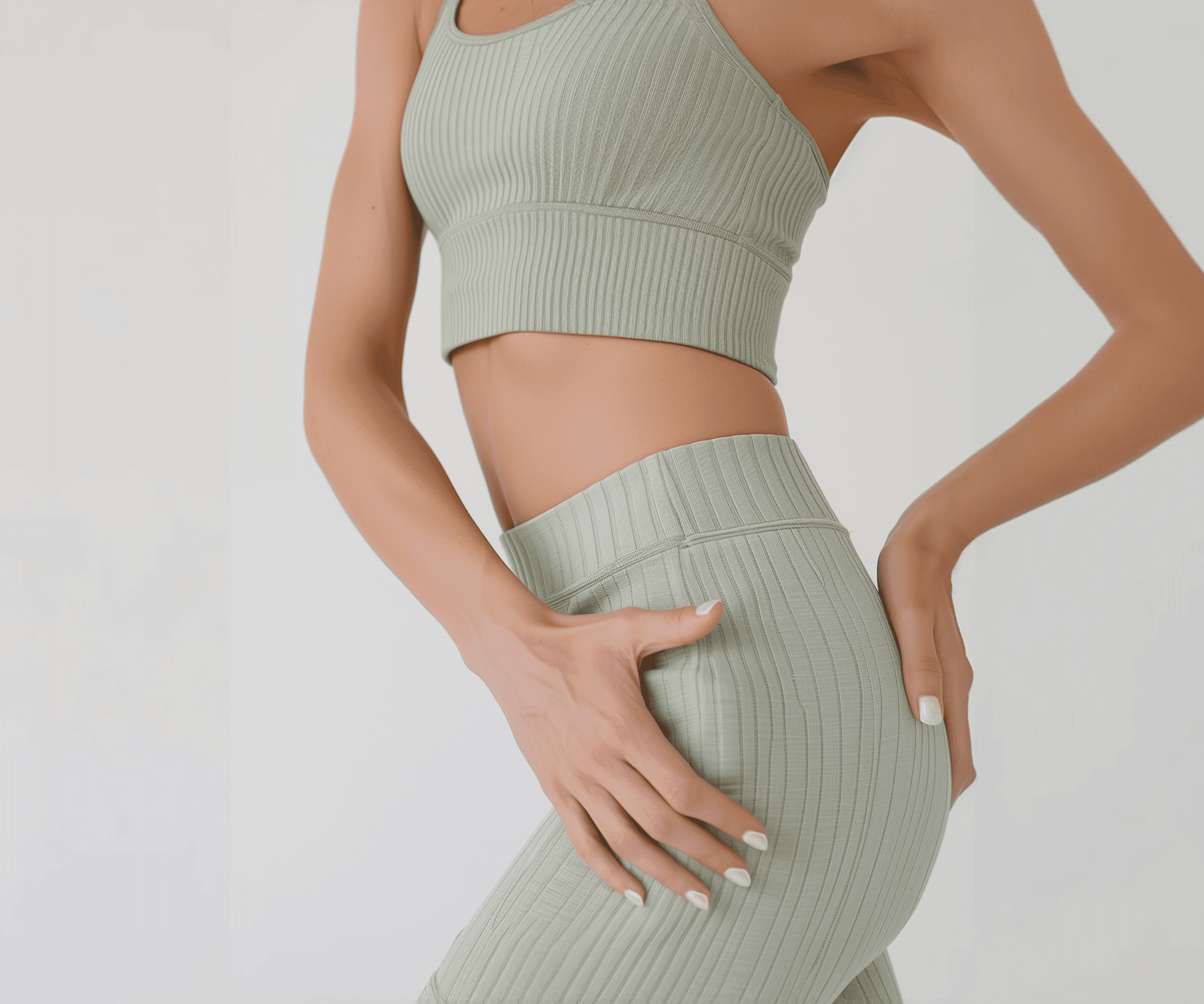 Woman in sage green ribbed activewear set against a white background