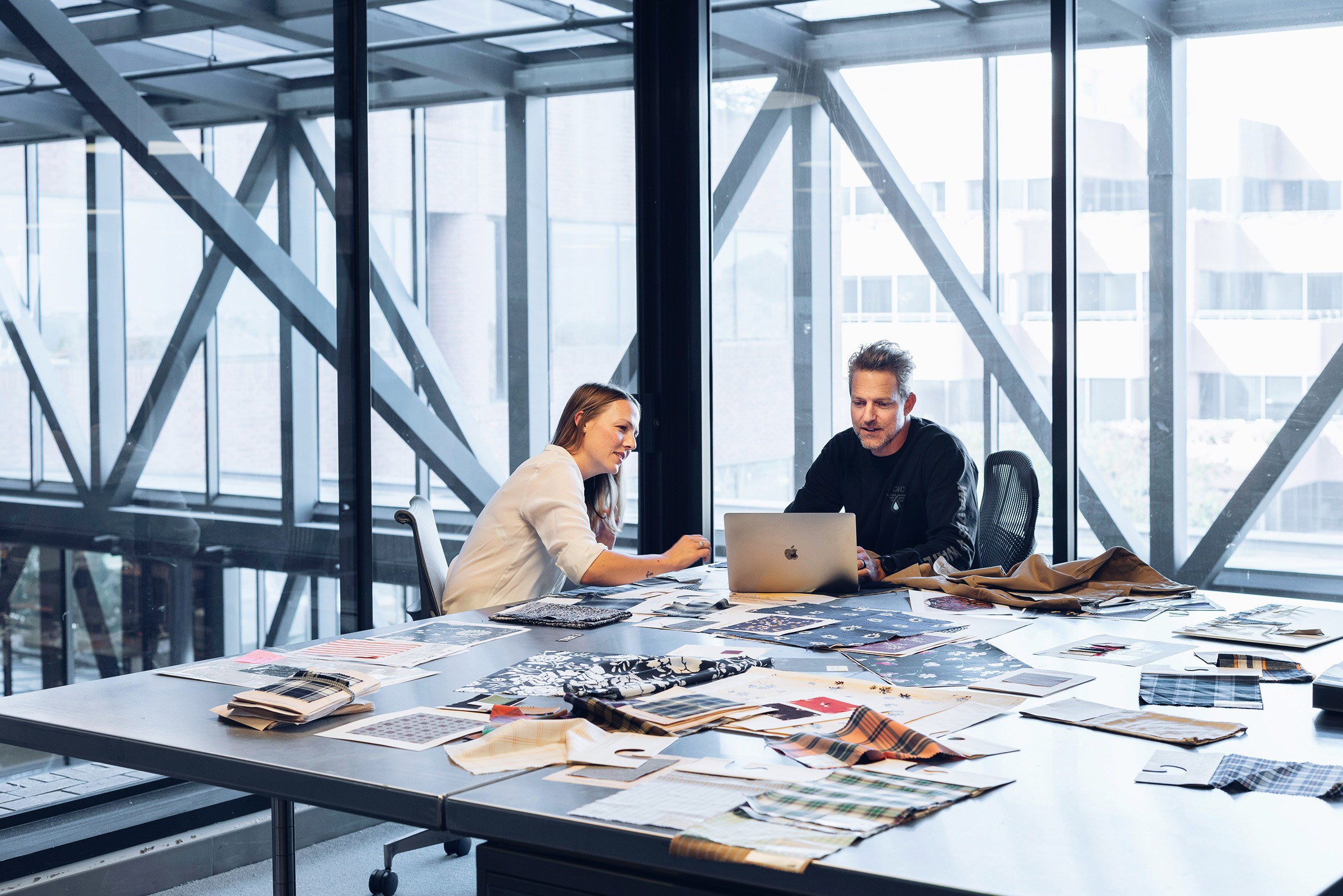 Man and woman working in a large industrial office.