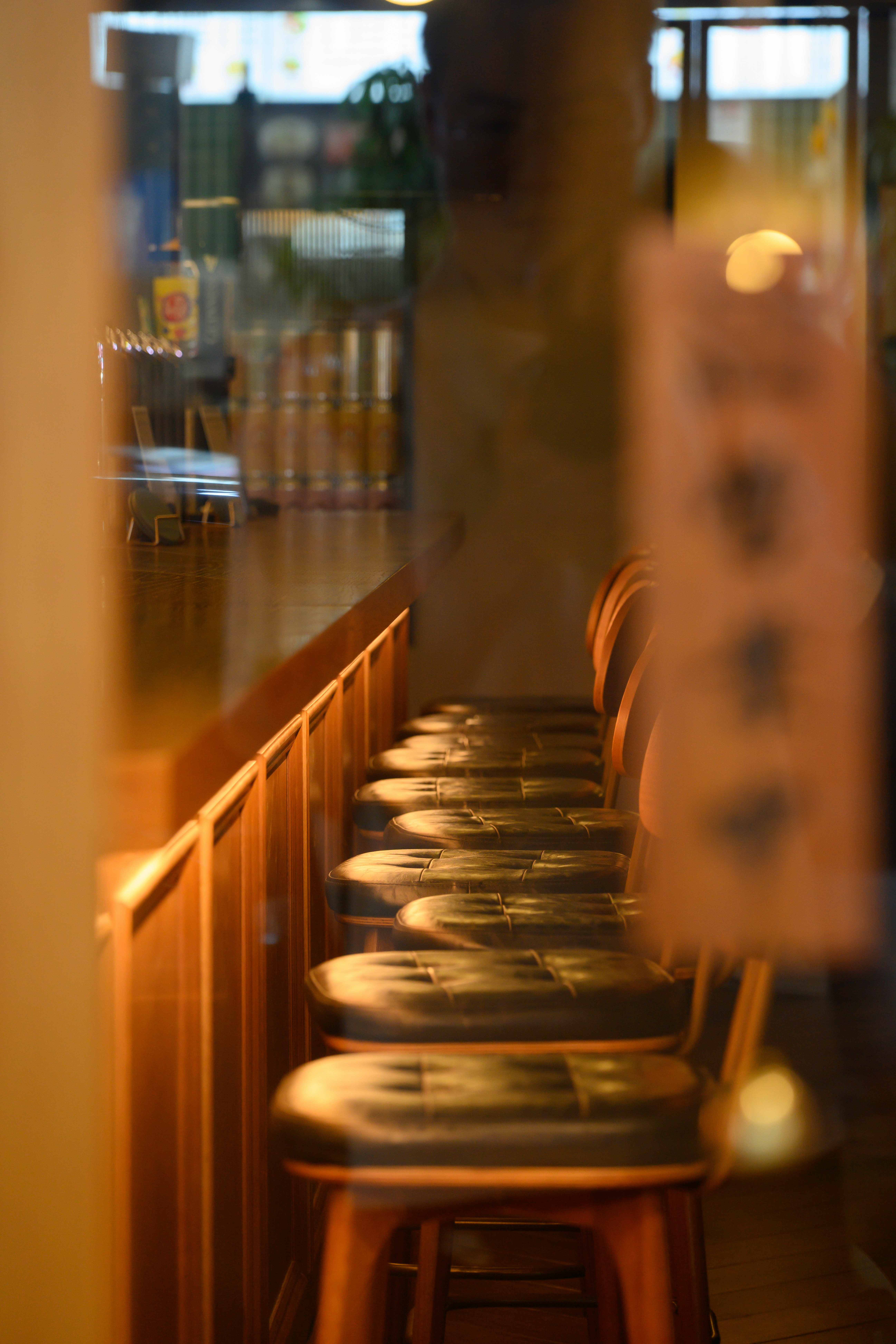 a row of wooden bar stools in a restaurant