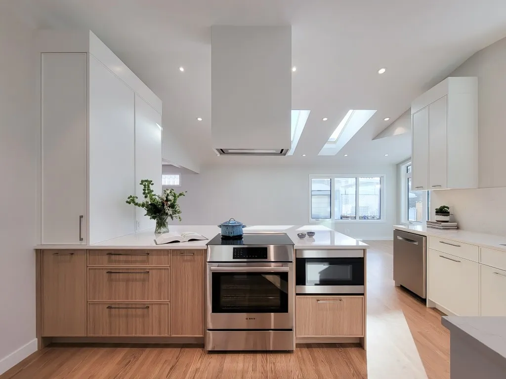 Image of Modern kitchen design with stainless steel appliances and white and wood cabinets by KHD Homes.