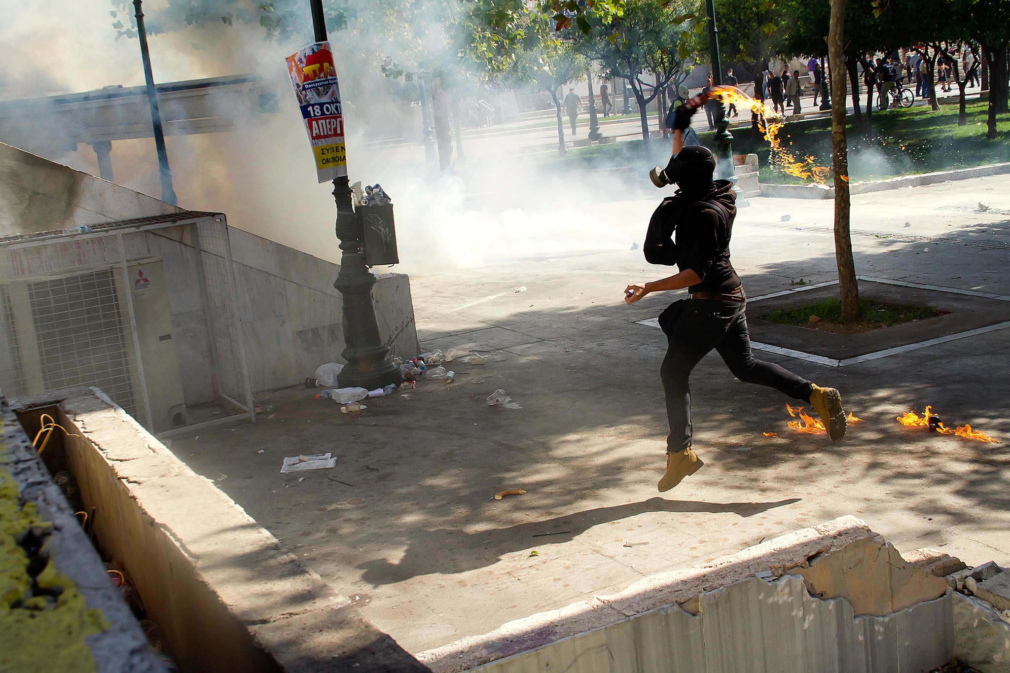 Riots in Athens, a protester is throwing a molotov cocktail. Action Photography, BBC Published