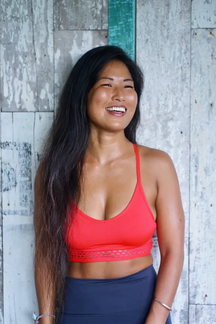 Vivienne Zeng riding a yellow scooter in Bali, enjoying the tropical lifestyle during yoga teacher training downtime.