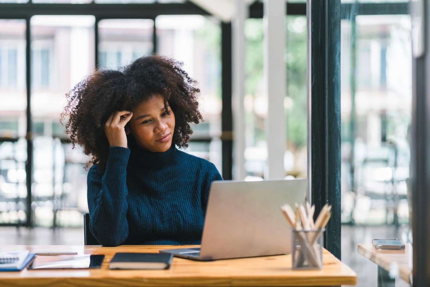 Femme en train de se demander si elle doit se reconvertir ou rester dans un travail qu'elle n'aime plus