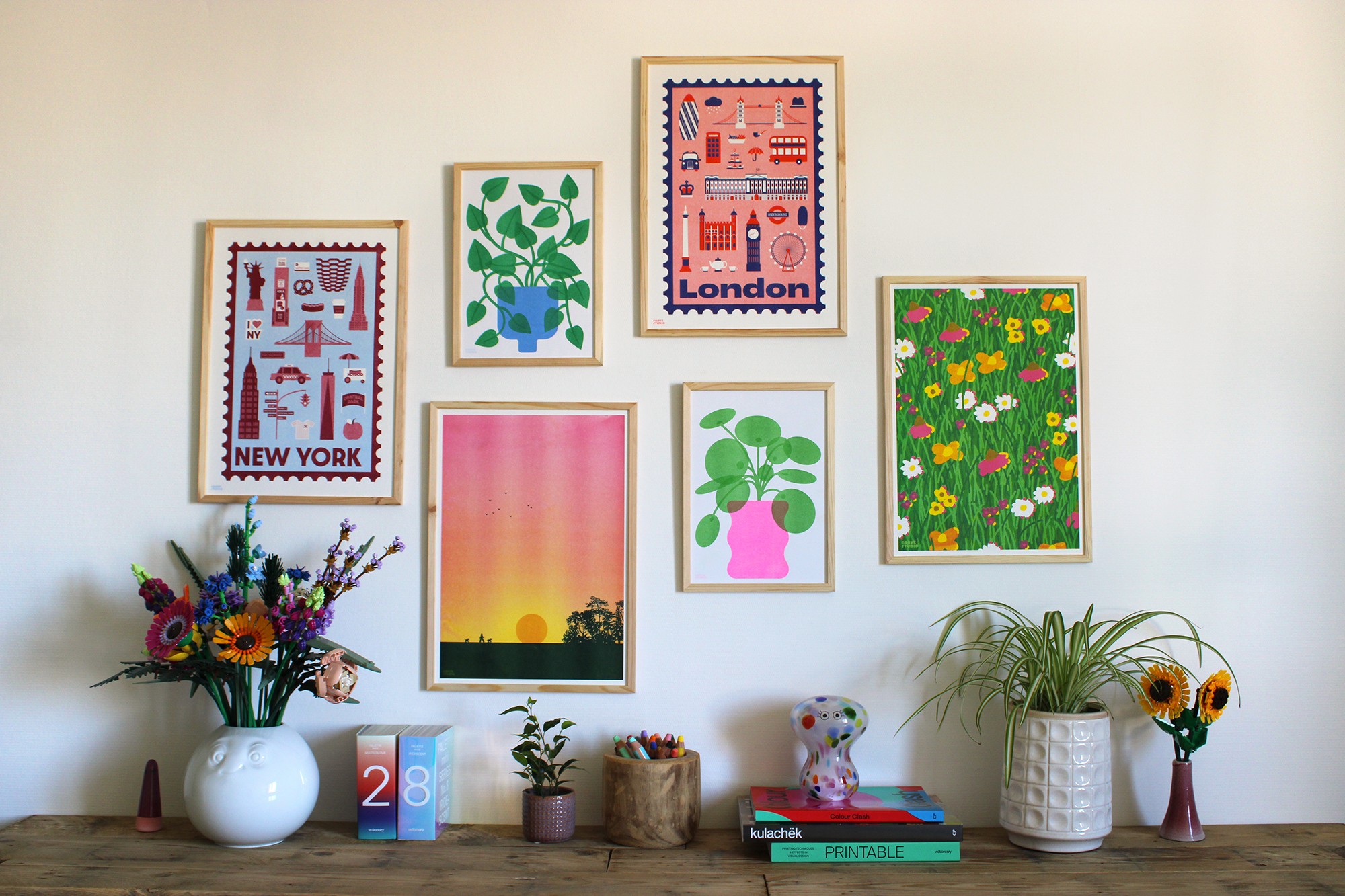 Mur de cadres avec décorations sur meuble devant