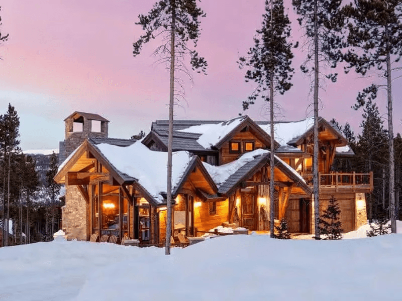 A snow-covered rental cabin in the wintertime for housing guests, cleaned by the MVP Cleaning team
