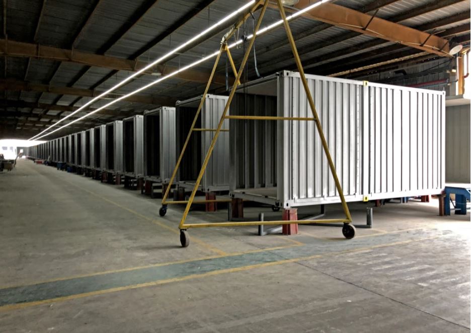 A row of unfinished corrugated steel modules in a Chinese factory, awaiting transformation into modern hotel guestrooms.