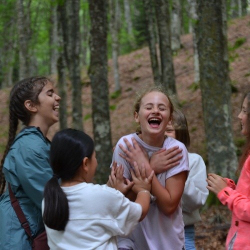Ragazzi che ridono insieme durante un campo estivo educativo in natura in Toscana
