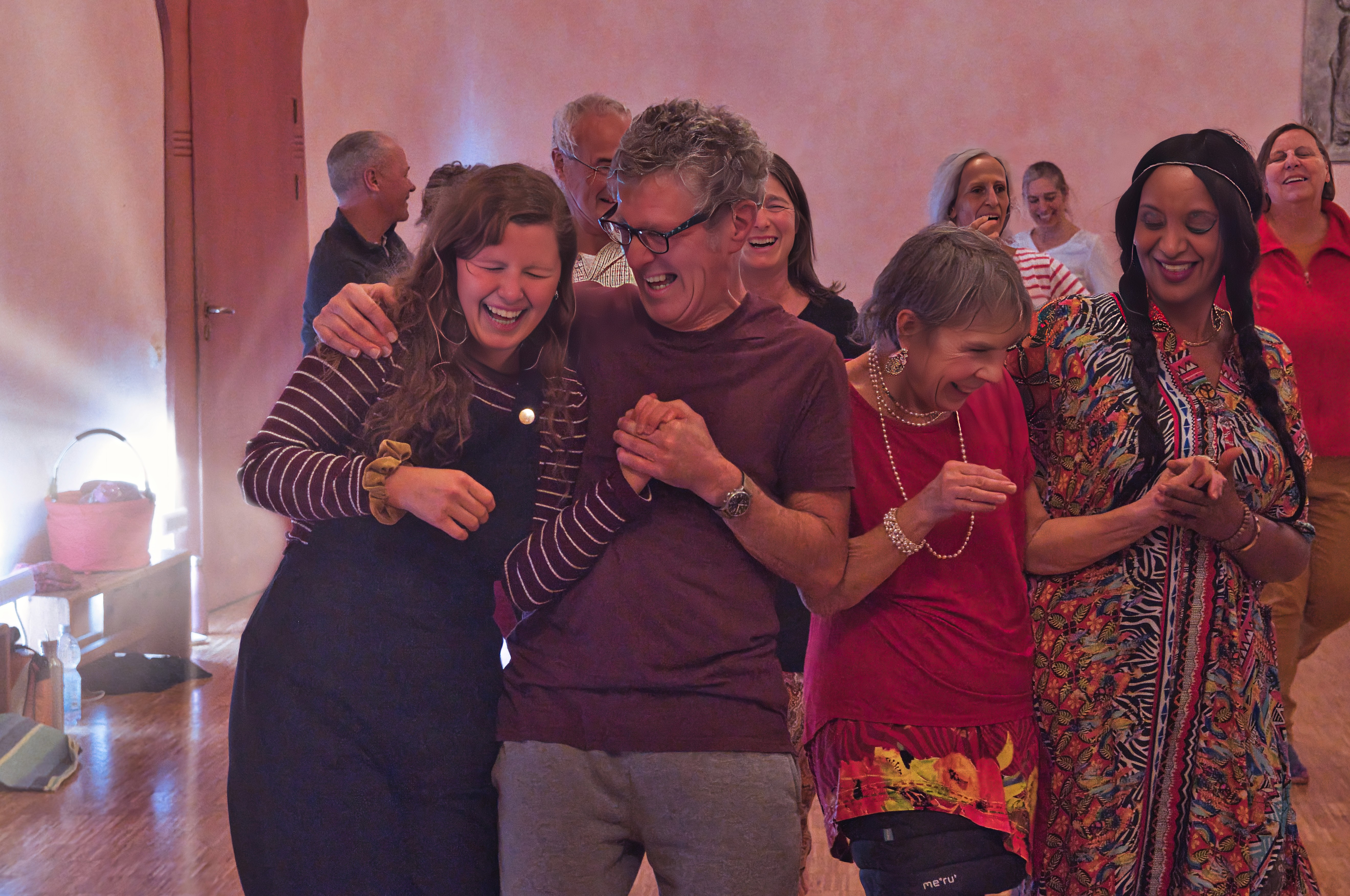 A serene and elegant spa space with wooden reclining chairs and white cushions. Golden sunlight filters through a cascading water feature, creating a peaceful atmosphere. Tropical plants and candles add to the relaxing ambiance.
