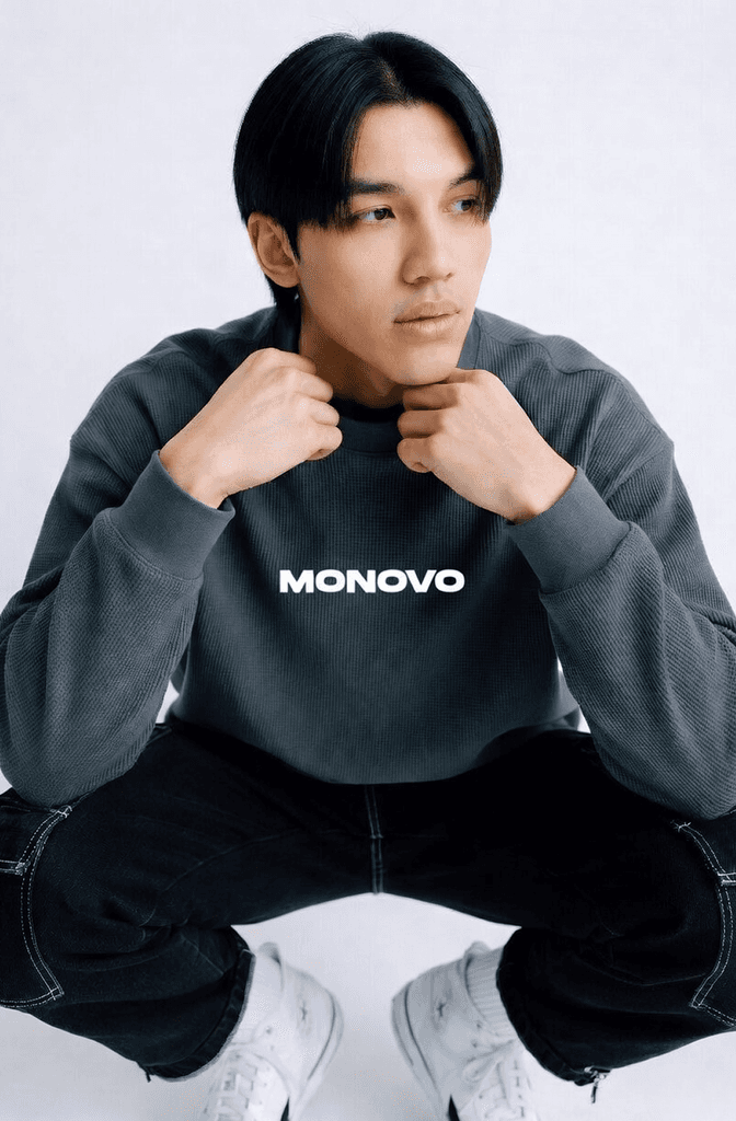 Man wearing a MONOVO sweatshirt sitting in a casual pose