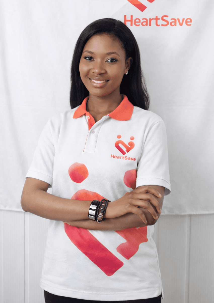 A young person with short brown hair in a purple shirt is looking at their phone against a dark green background.