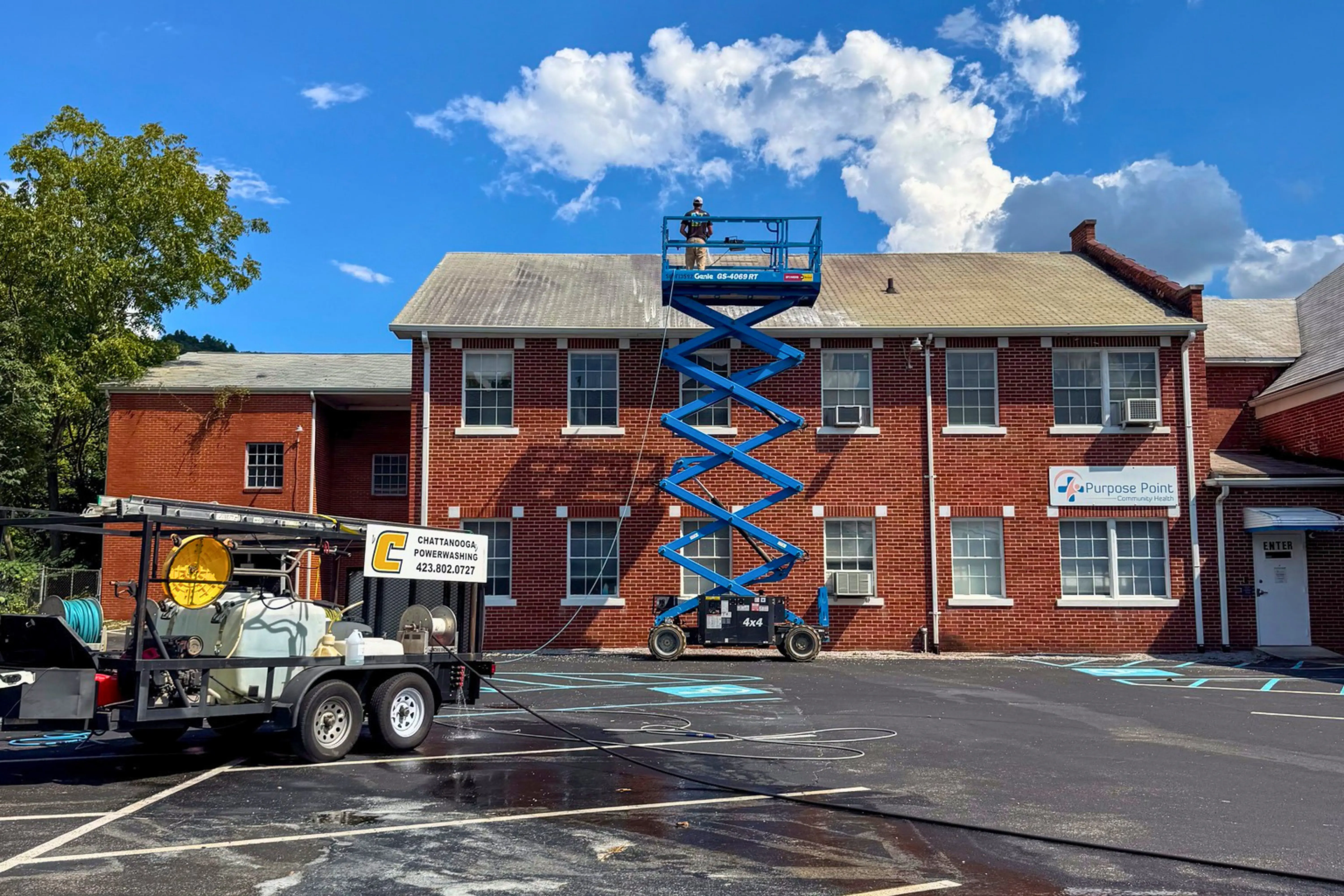 a man in a yellow shirt is working on a roof
