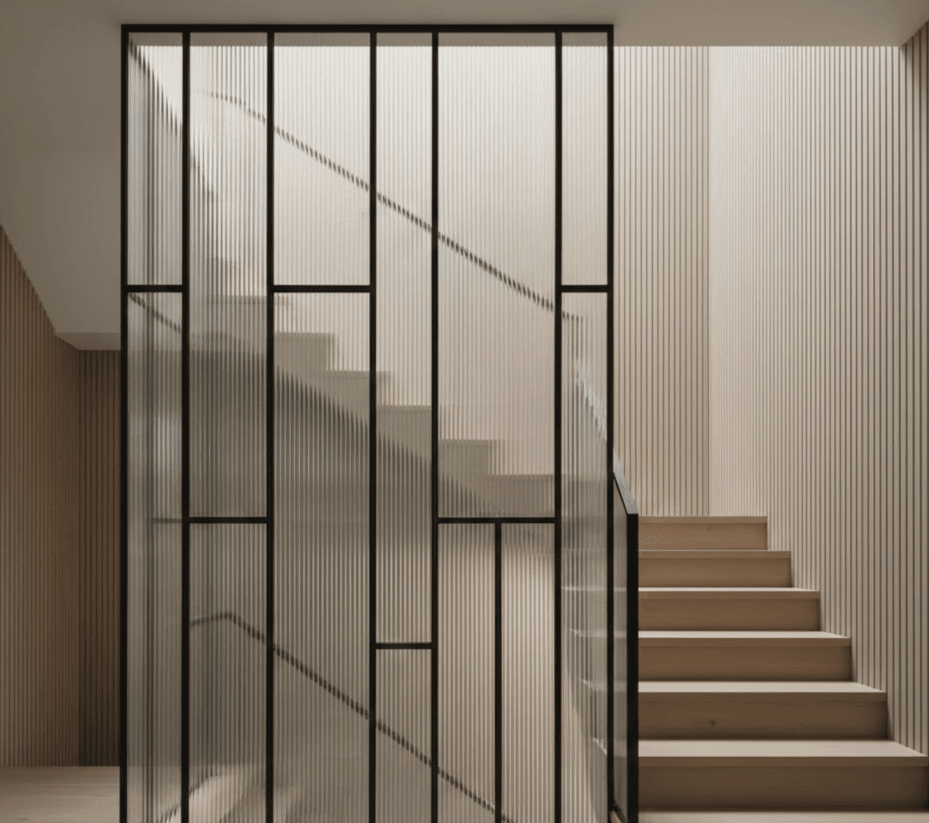 Modern staircase featuring vertical reeded glass balustrade panels.