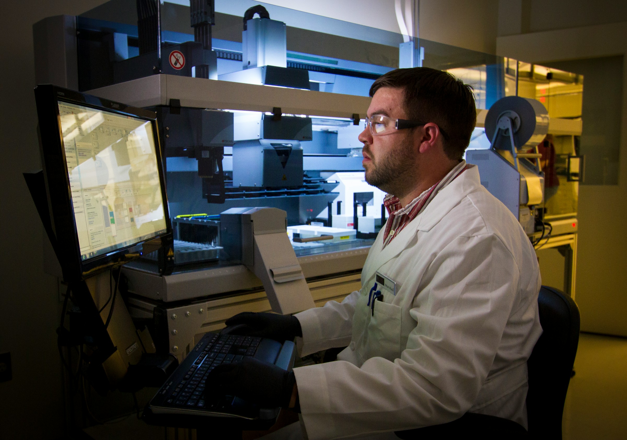 man infront of a computer in clinic - Clinical Research Collaboration