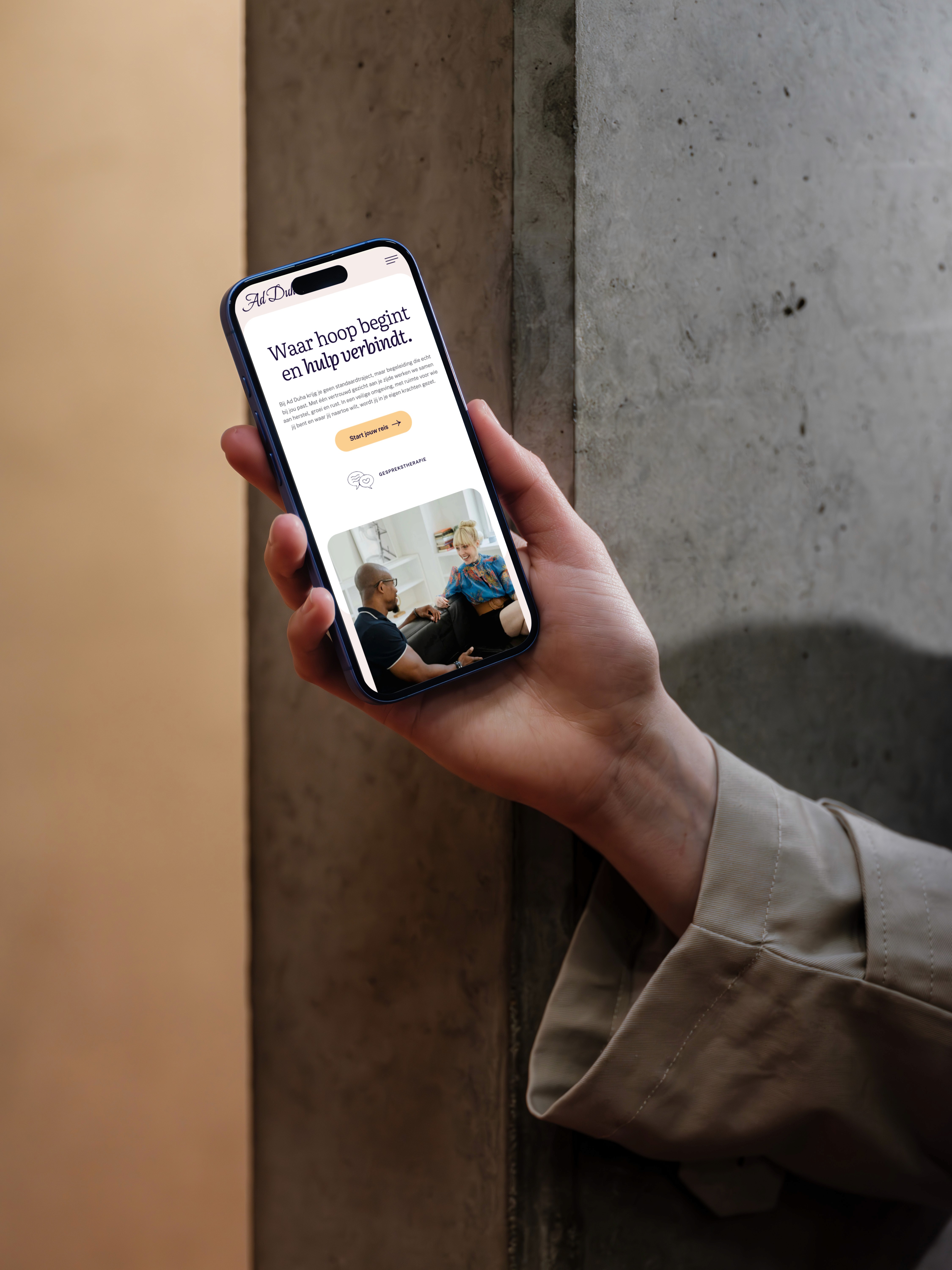 Persoon die telefoon vasthoud en daarop Ad Duha website open heeft
