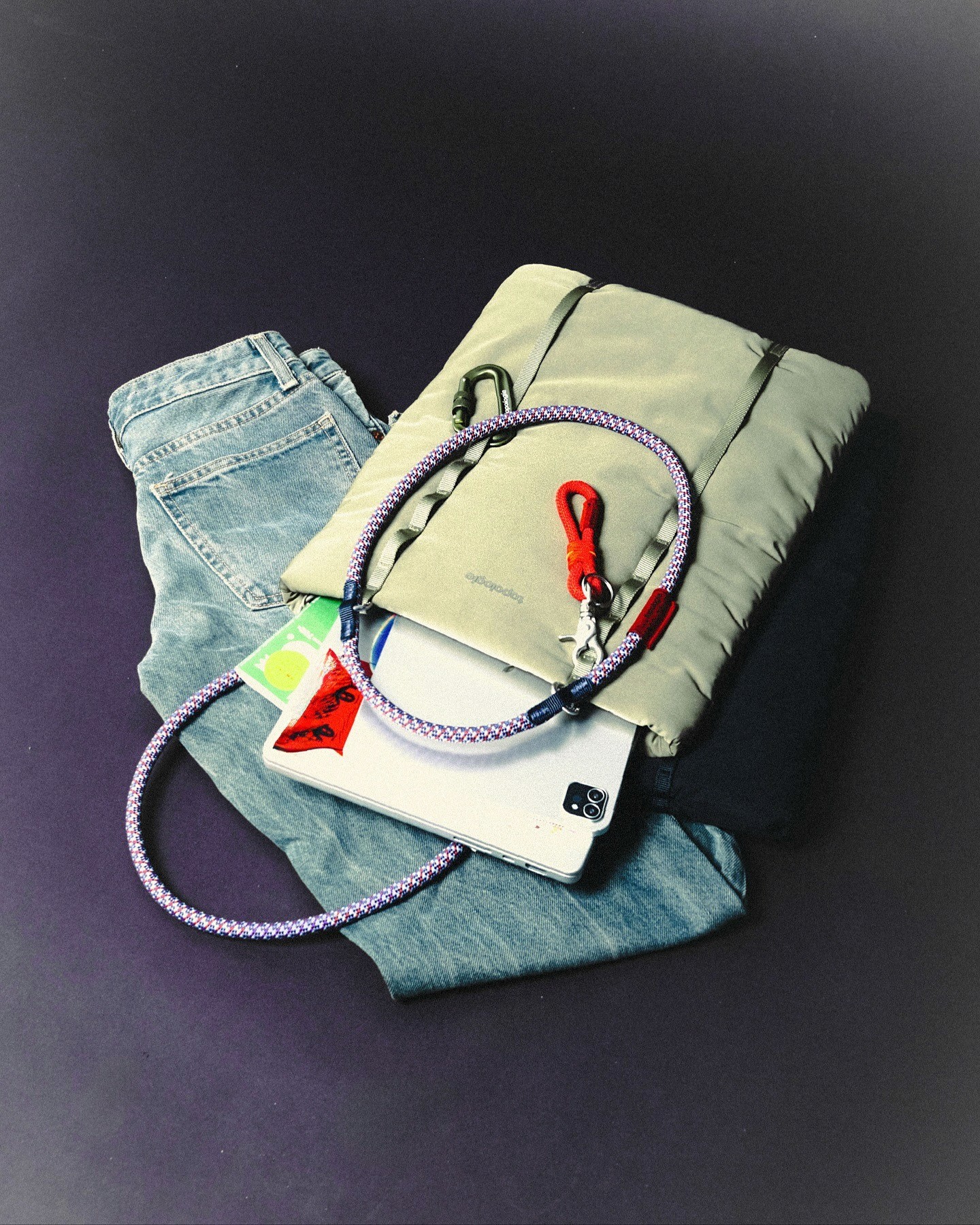 Un sac format ordinateur vert clair est posé sur un jean