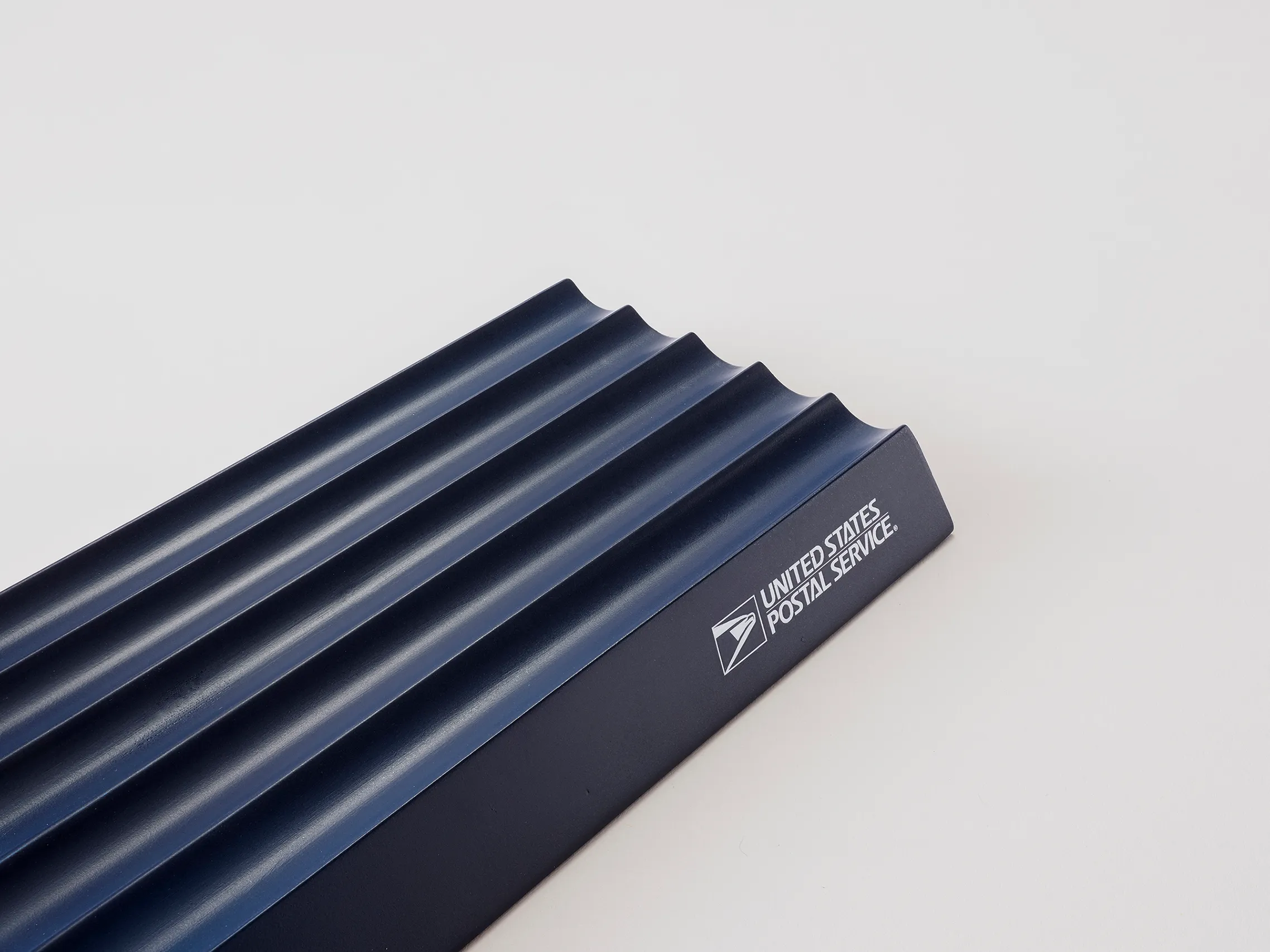 Close-up of the USPS mailbox sensor showing its horizontal slats and branded edge