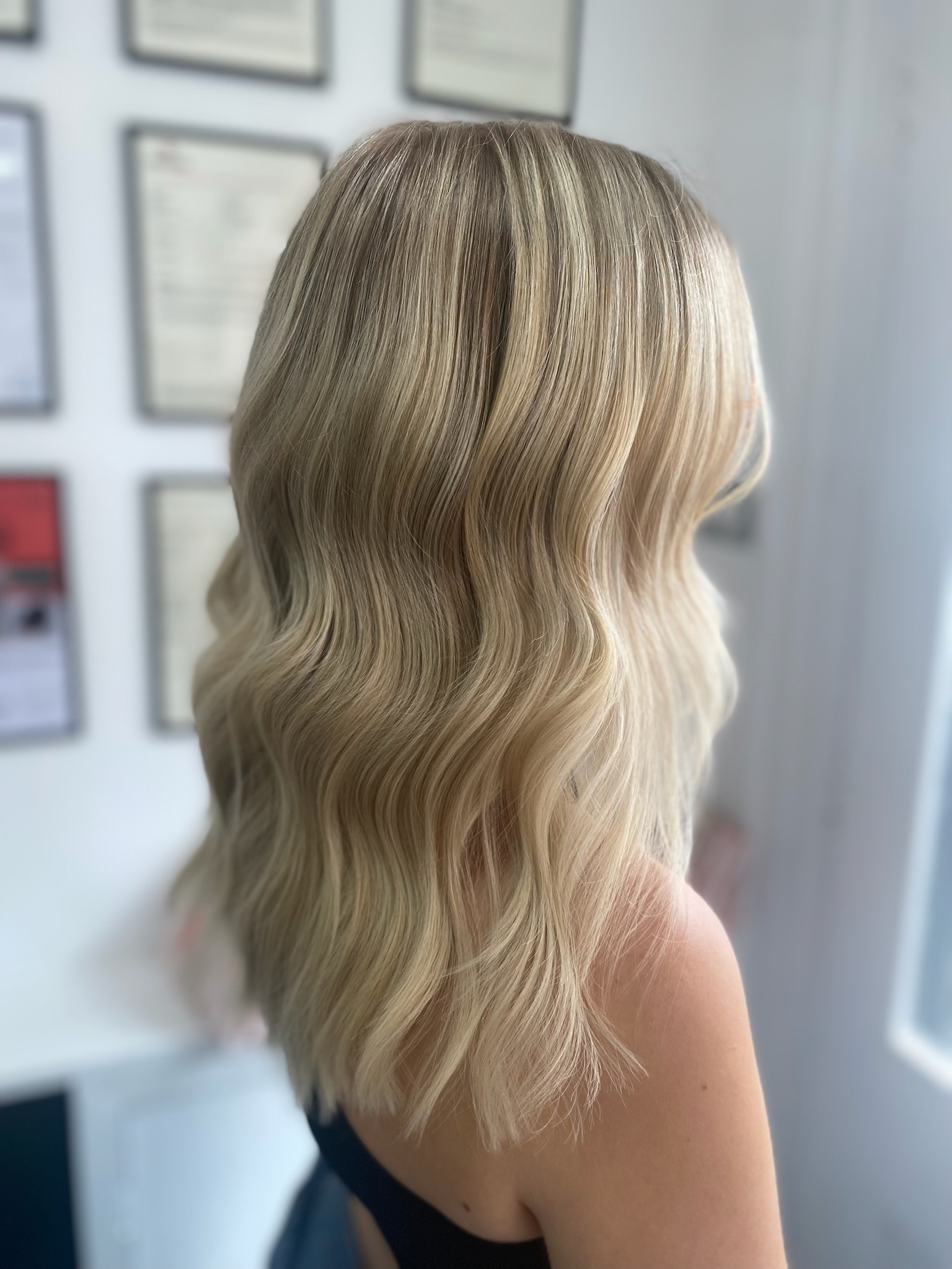 Smiling woman with long wavy brunette hair and blonde fringe