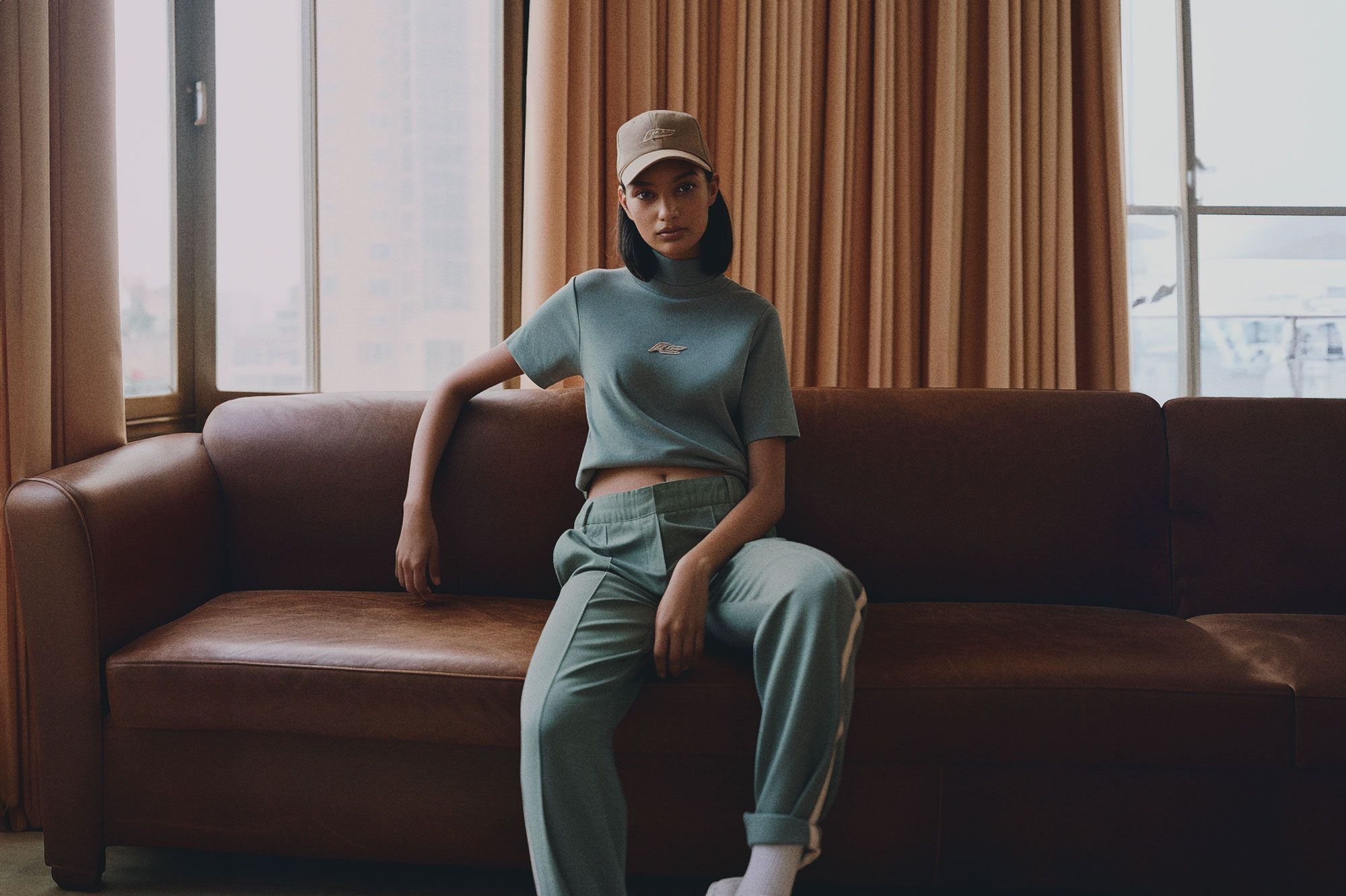 Women in streetwear sitting on leather couch