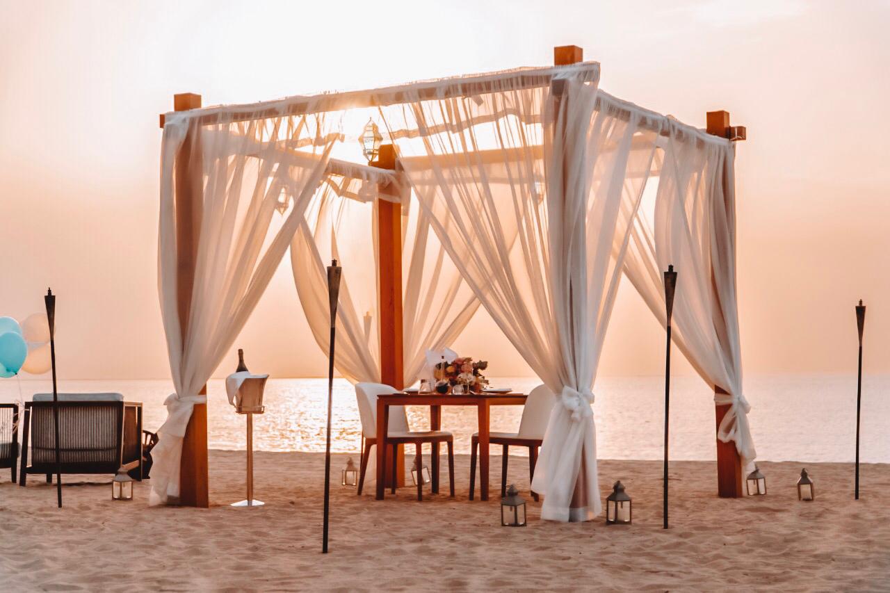 Black-and-white party photo of a smiling man in a check blazer among a crowd.