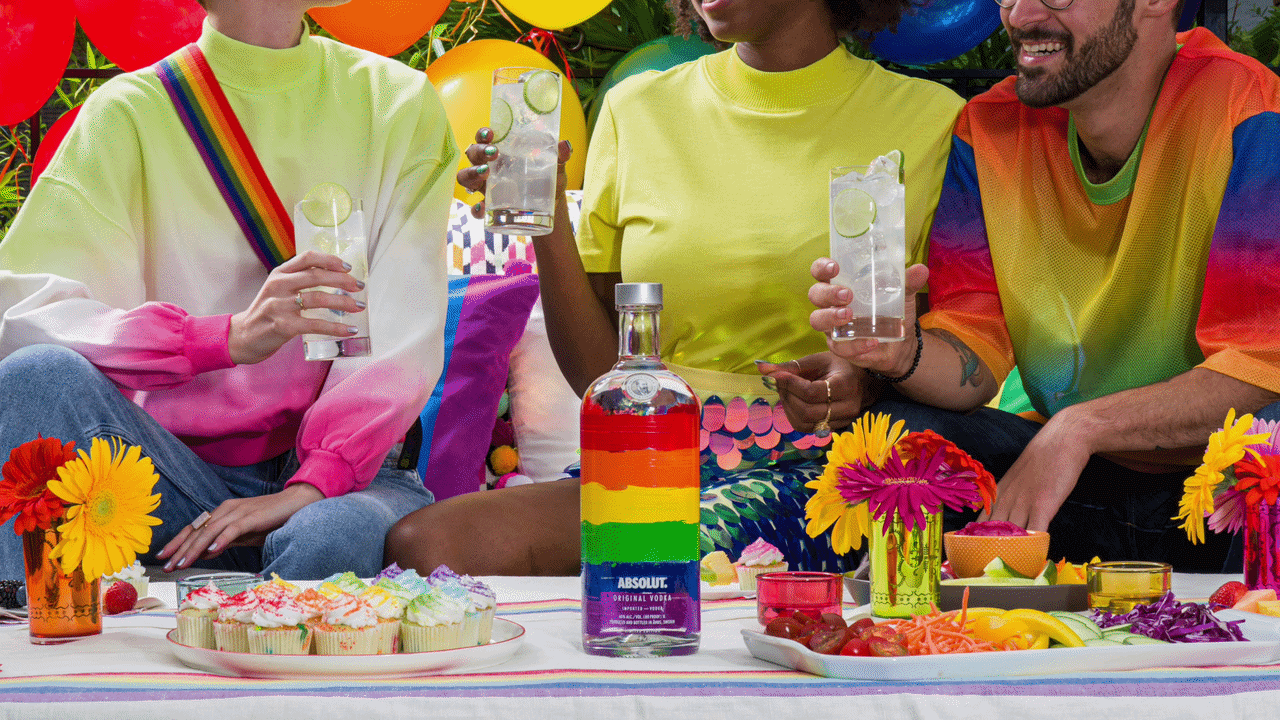 Friends in bright Pride looks toasting around a rainbow Absolut bottle and festive table, from the Pride occasion in Ford Media Lab's Absolut content calendar.