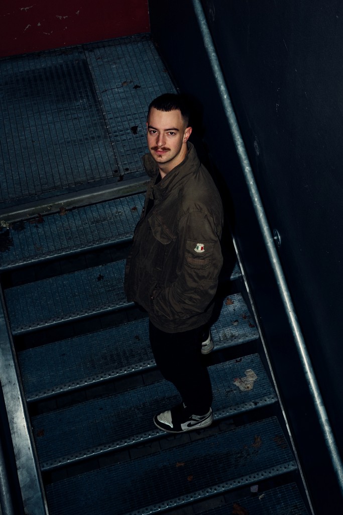 Young man on a staircase captured with direct flash