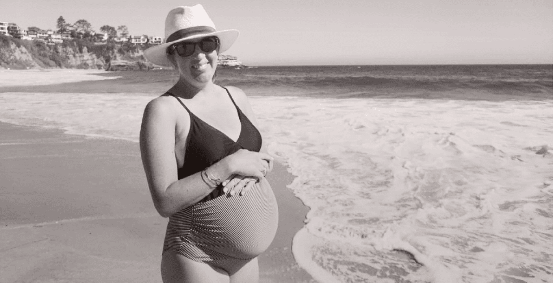 Pregnant woman smiling on a beach