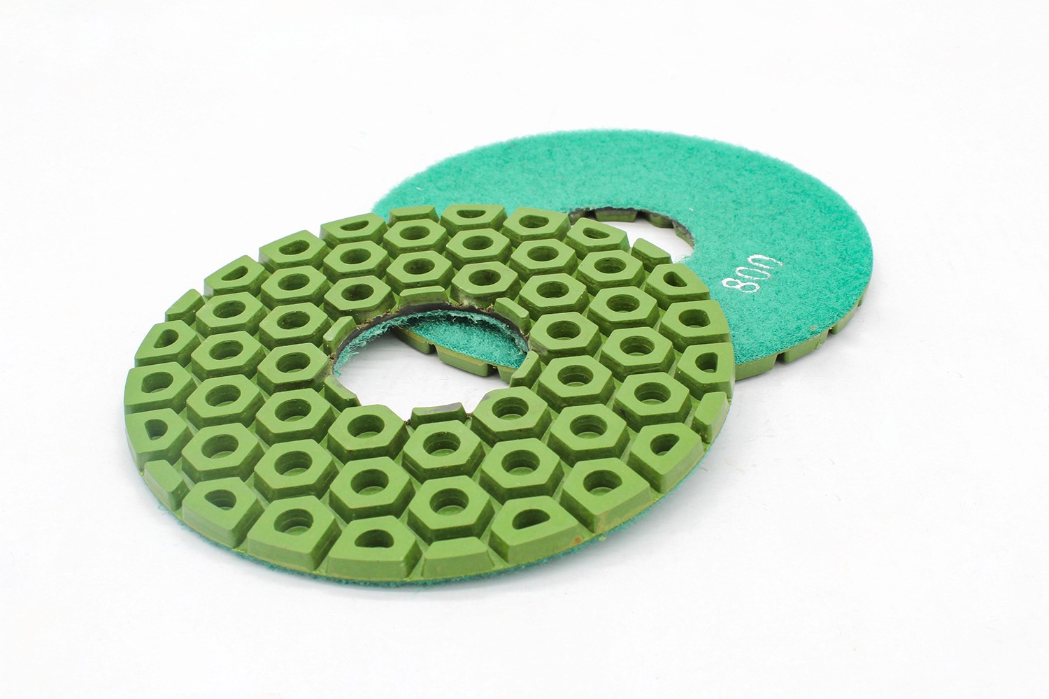 Two green resin bond diamond polishing pads, one facing up and one down, showing the hexagonal pattern and the back.