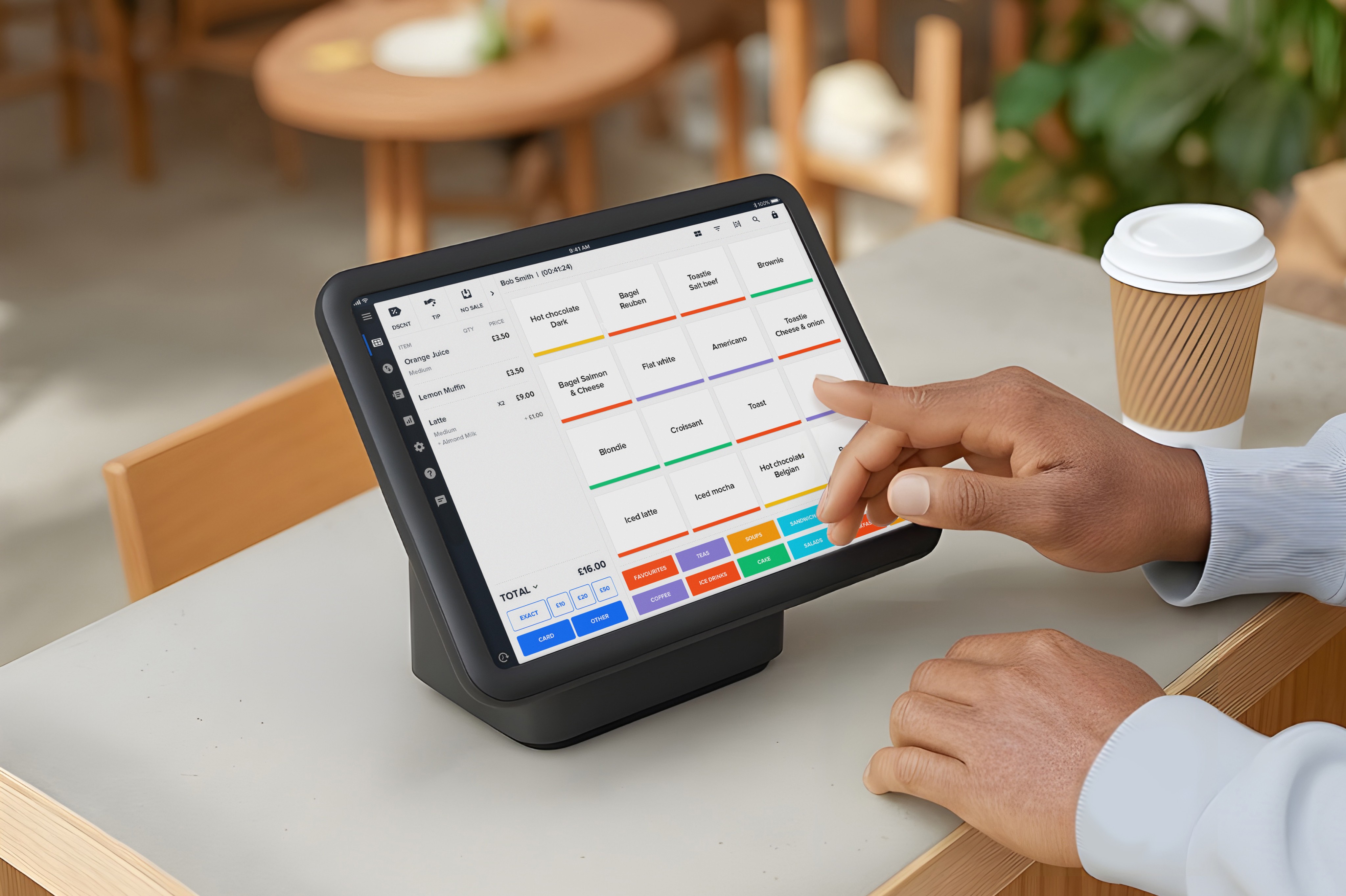 User interacting with Akru POS touchscreen interface to manage orders and payments in a café setting