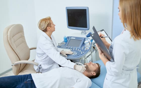 Лікар проводить УЗІ шиї пацієнта