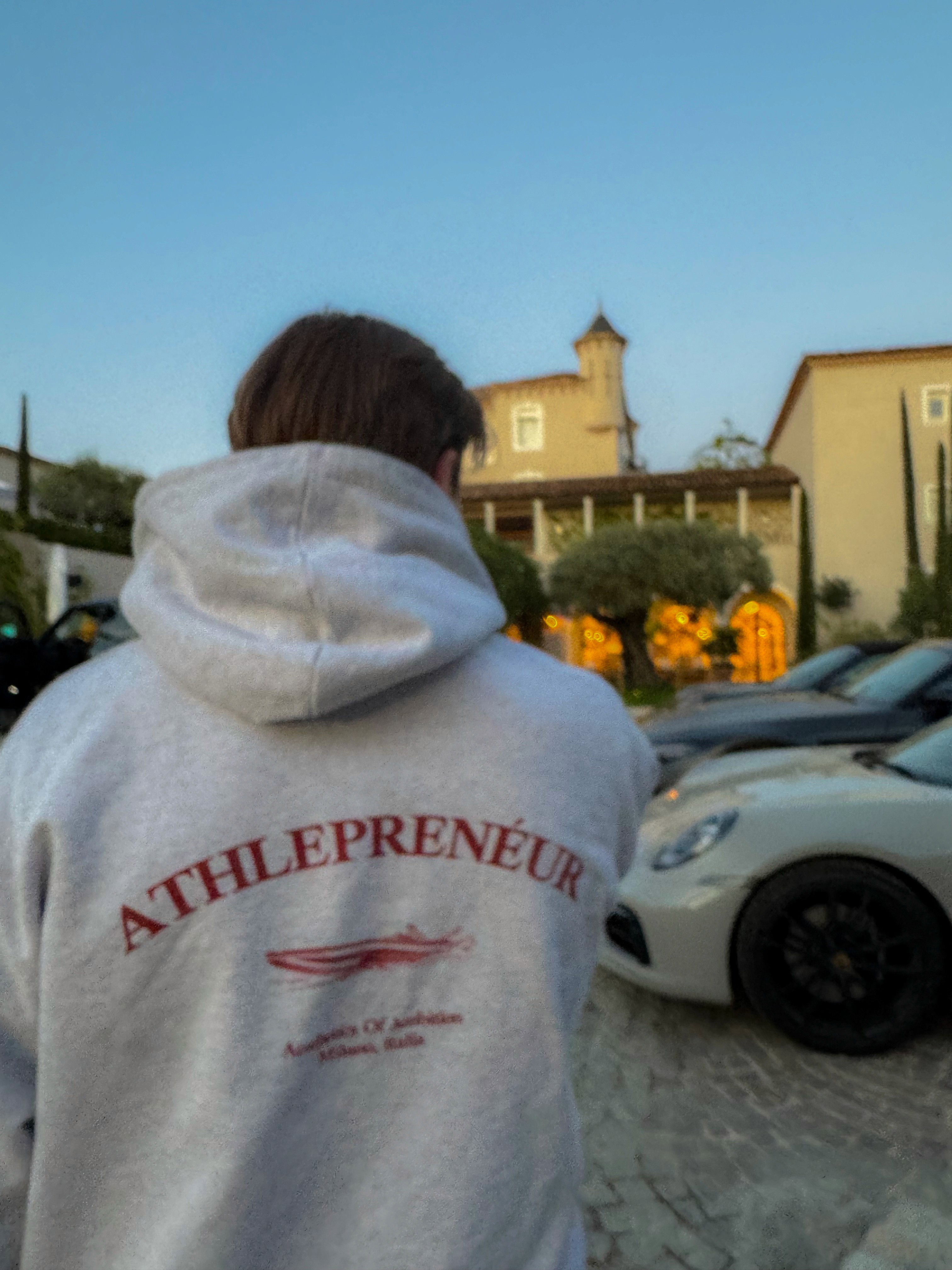 A man films a sunset through a large window in a modern home.