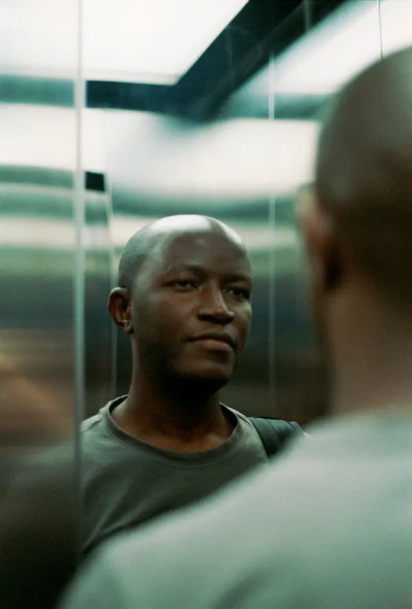 Man in fur hat hiding face with scarf at night.