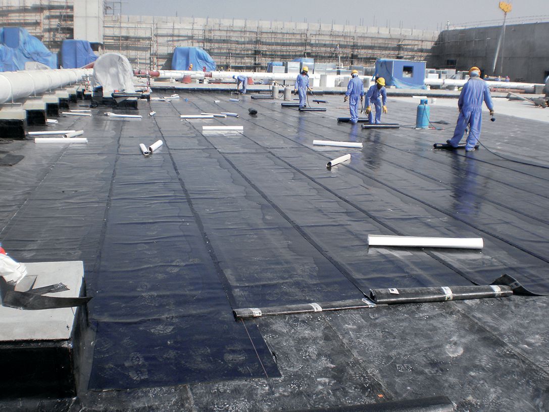 香港天台防水工程：專業師傅於地盤鋪設黑色防水卷材，確保屋頂防漏，Branding Works Floor 專業防水工程服務。