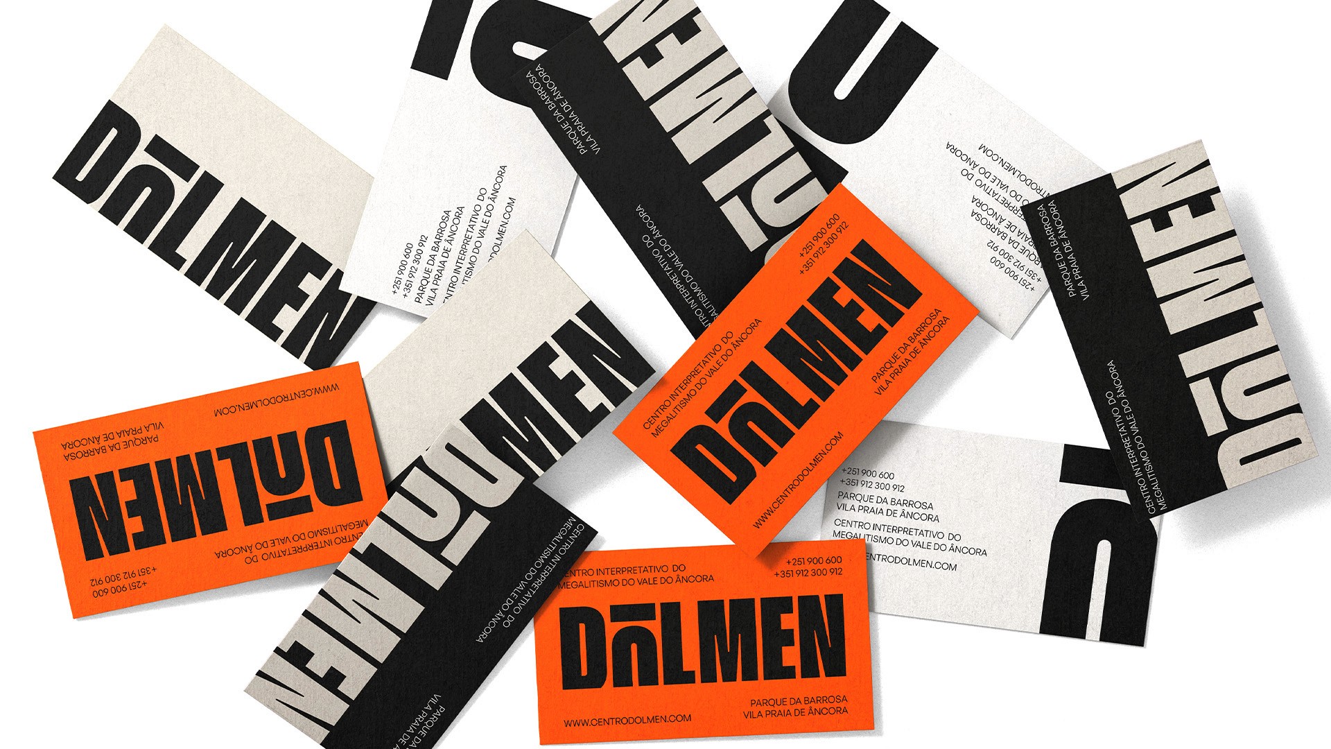 Dolmen business cards in orange, black and cream featuring the distorted megalithic-inspired wordmark 