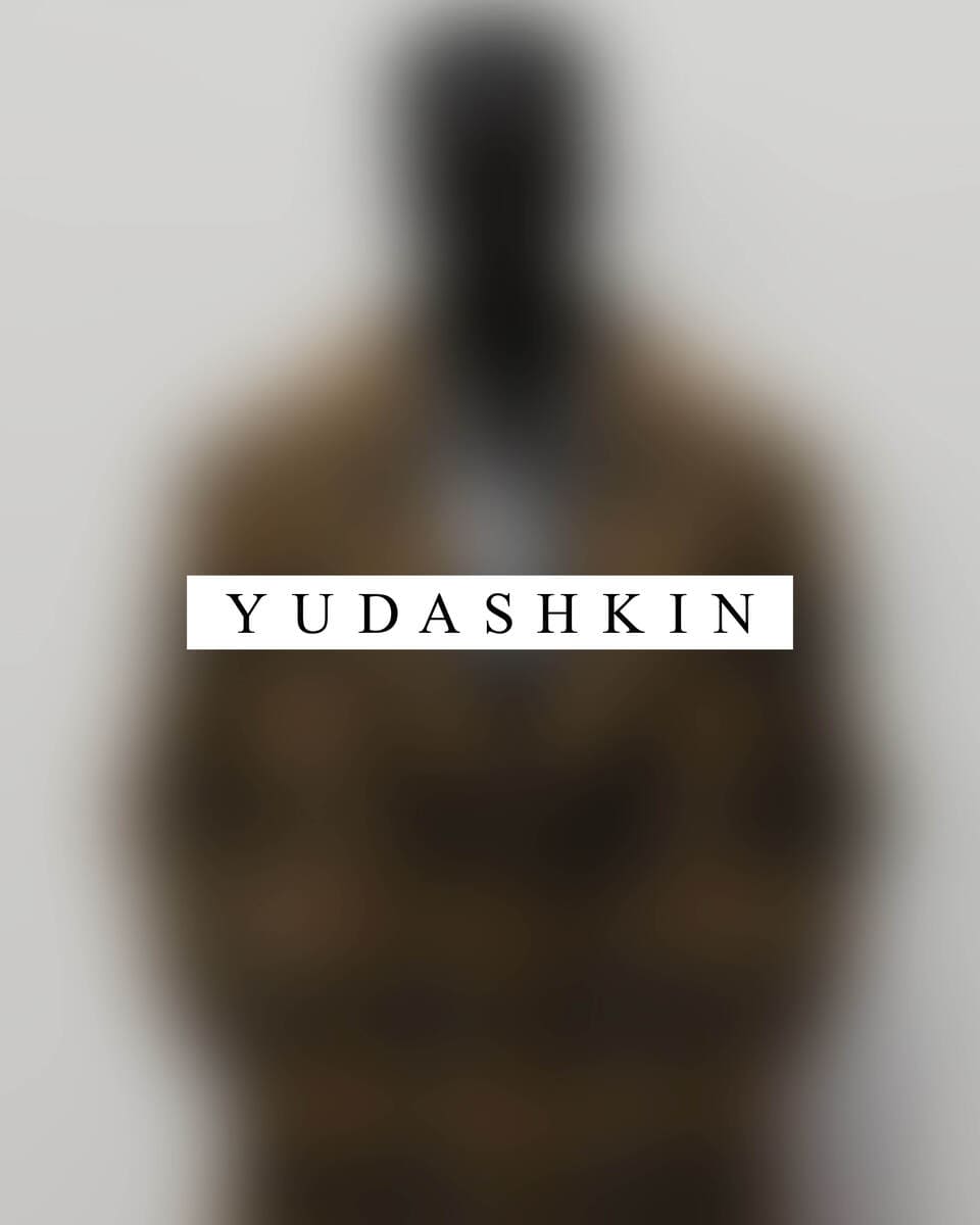 A blurry background photo of a person with a text that says yudashkin.