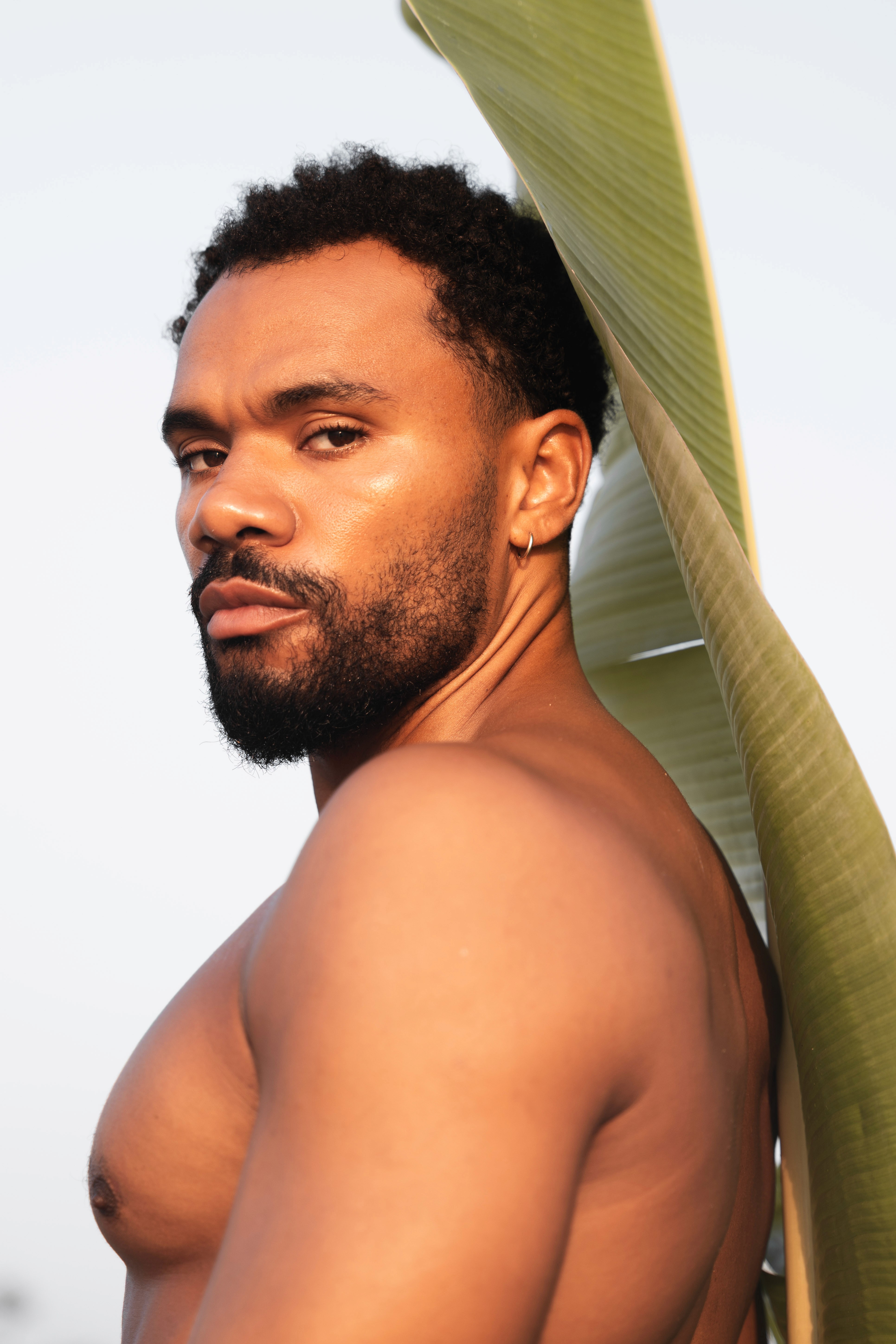 Girl laying in bikini in the sand looking straight into the camera