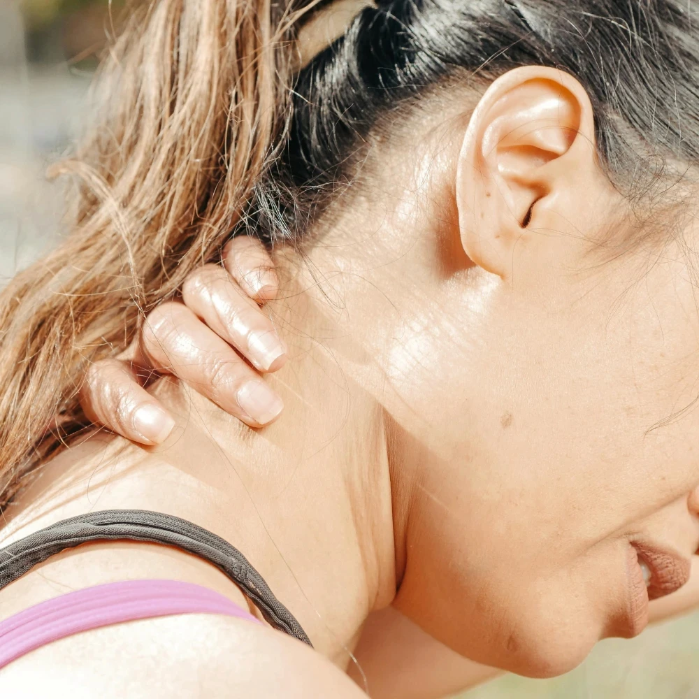 A woman holding her neck in pain