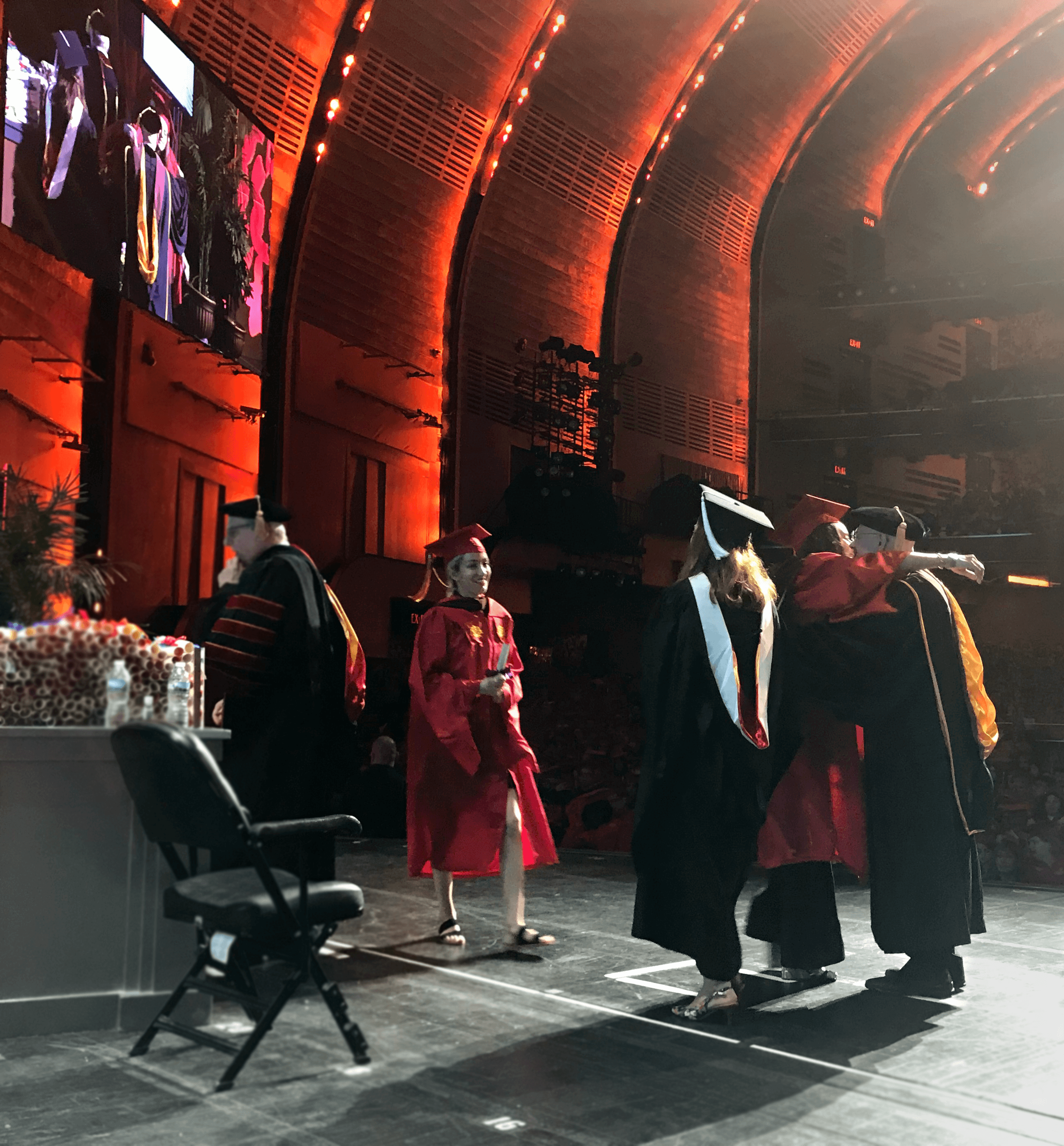 A photo of a group of students and teacher on a stage at the graduation ceremony.