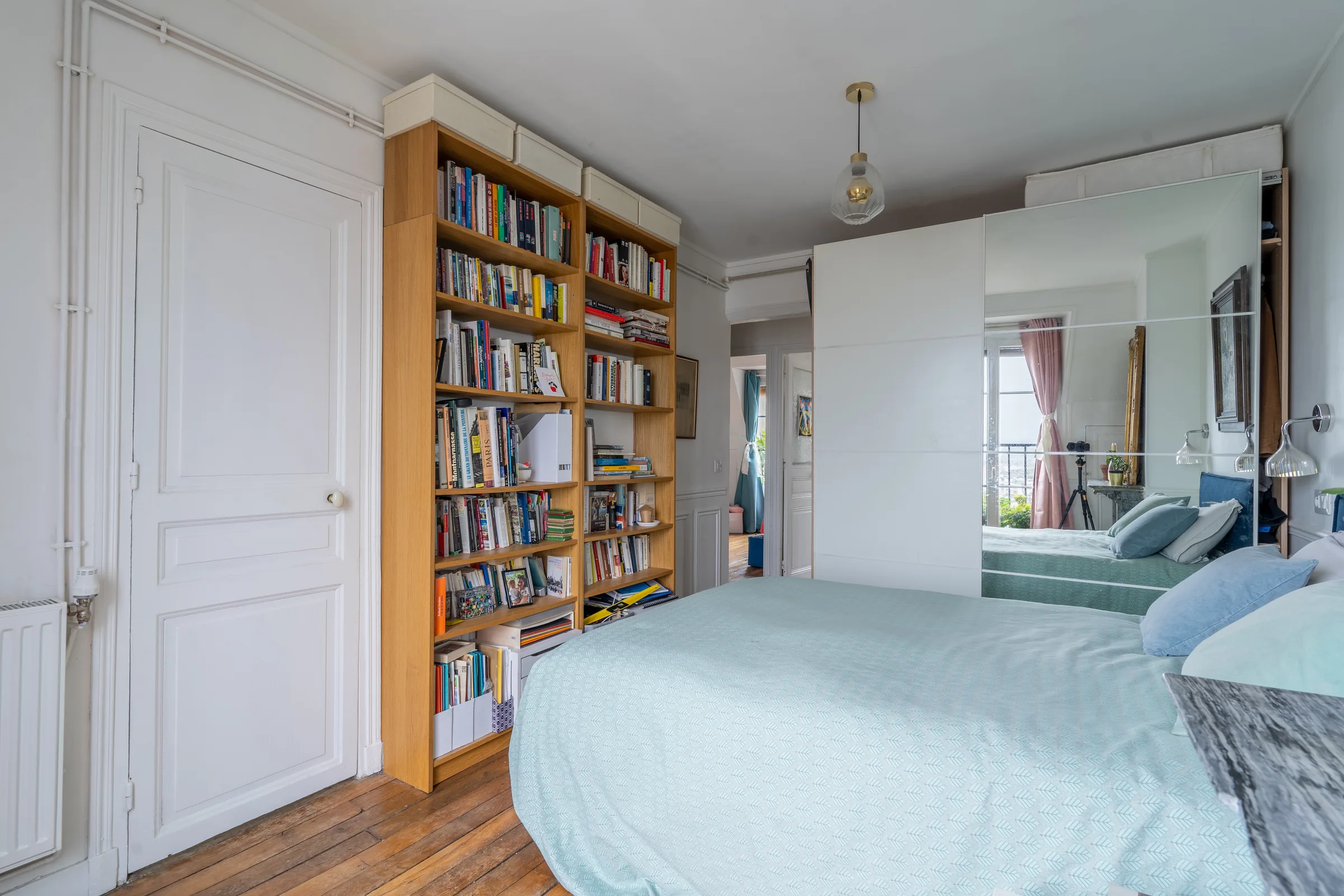 Montmartre bedroom with bookshelves — Paris, France. Photography by Yunes Calore.