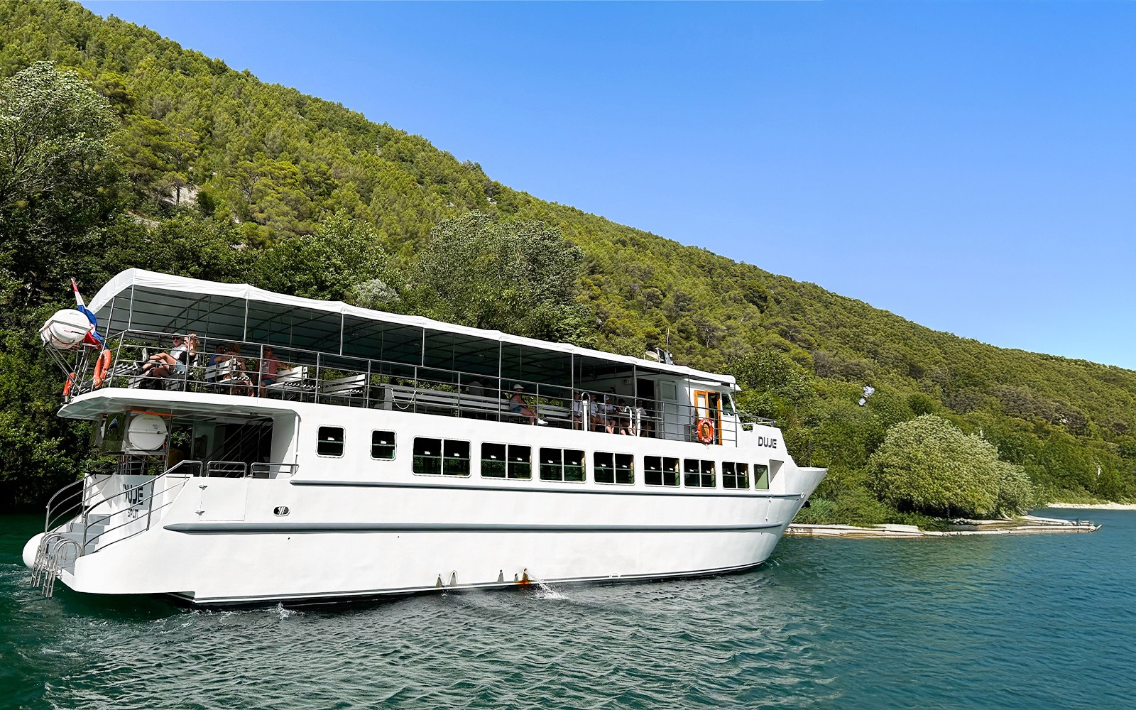 Boat with guests cruising through Krka National Park, Croatia.