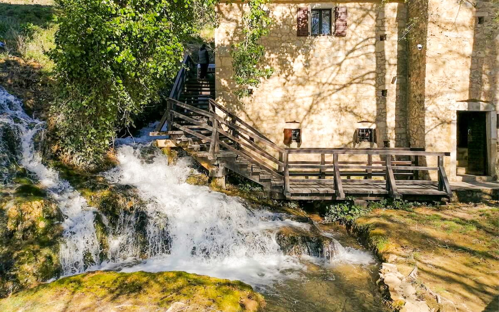 克罗地亚克尔卡国家公园内的石建筑和木桥跨越瀑布。