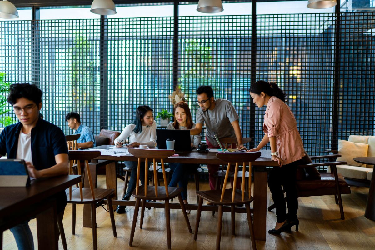People working at a table with laptops and papers.