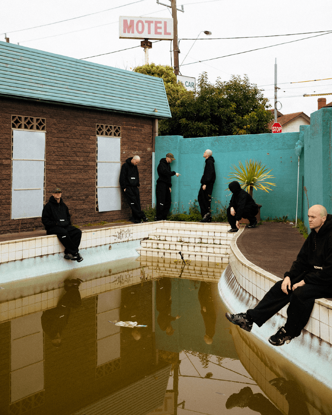 Close-up of hand holding pink ice cream cone against pastel background